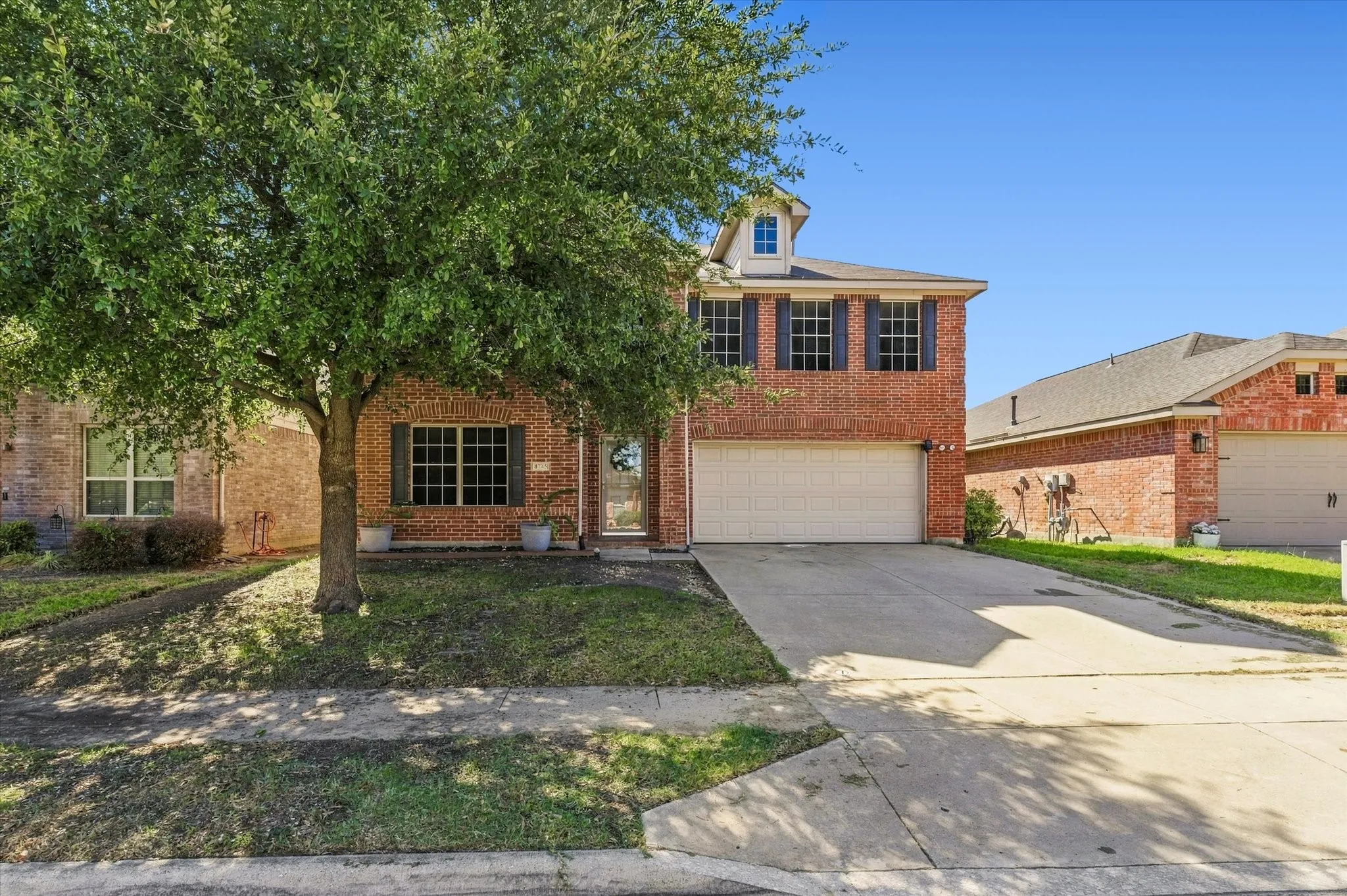 Brick exterior with a dormer window and an attached garage