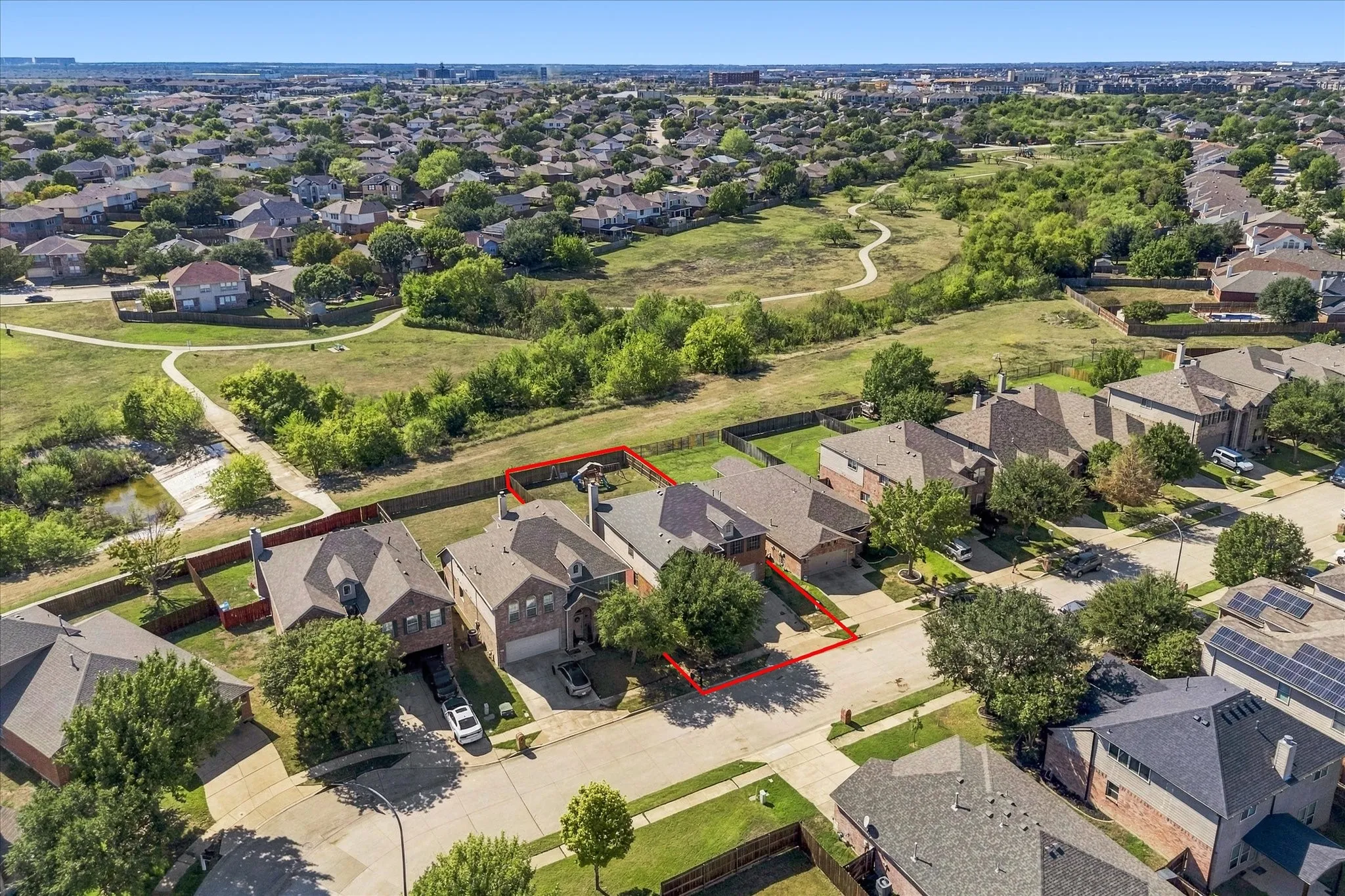 Residential property with a brick exterior, attached garage, and a fenced backyard