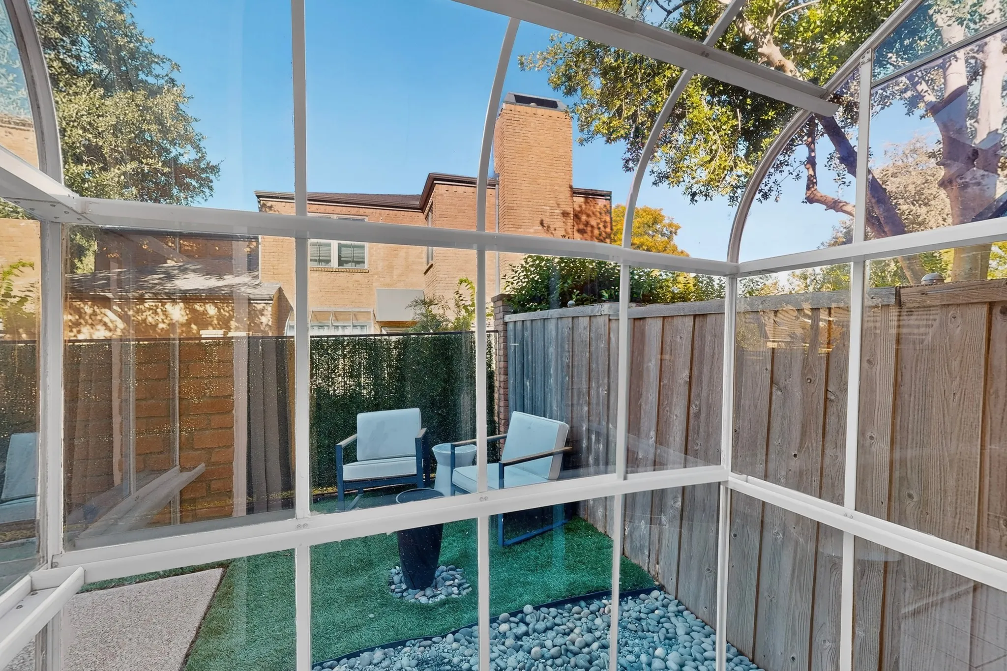 Enclosed outdoor structure with a glass roof and wall panels, offering a private setting