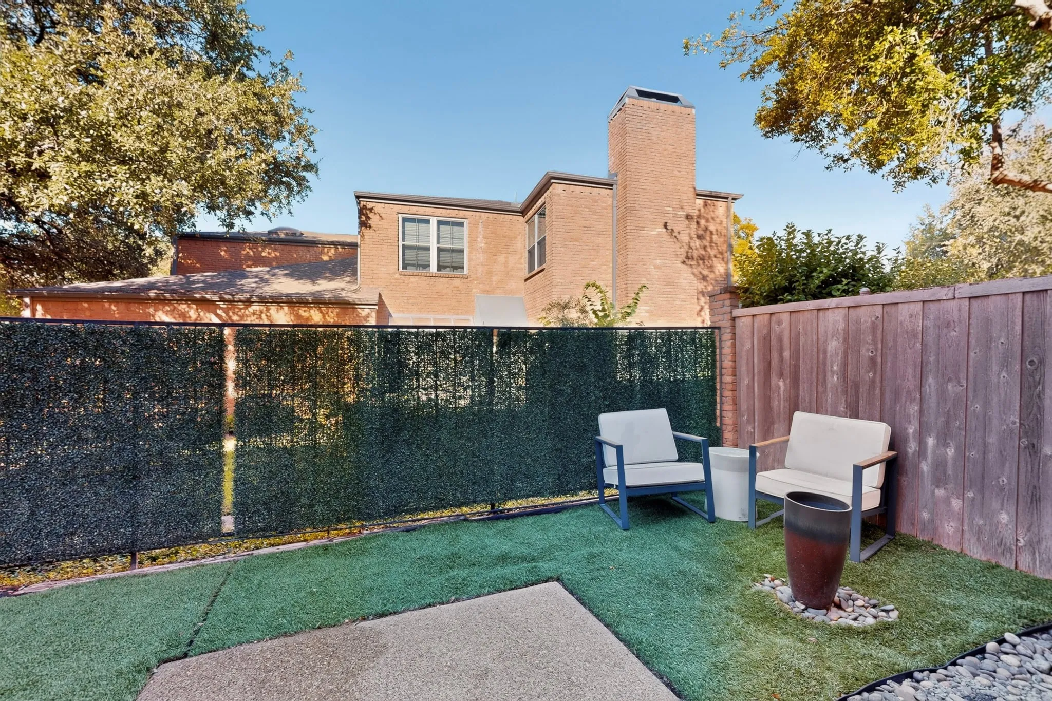 Fenced outdoor area featuring artificial turf, a wood panel fence, and a privacy screen