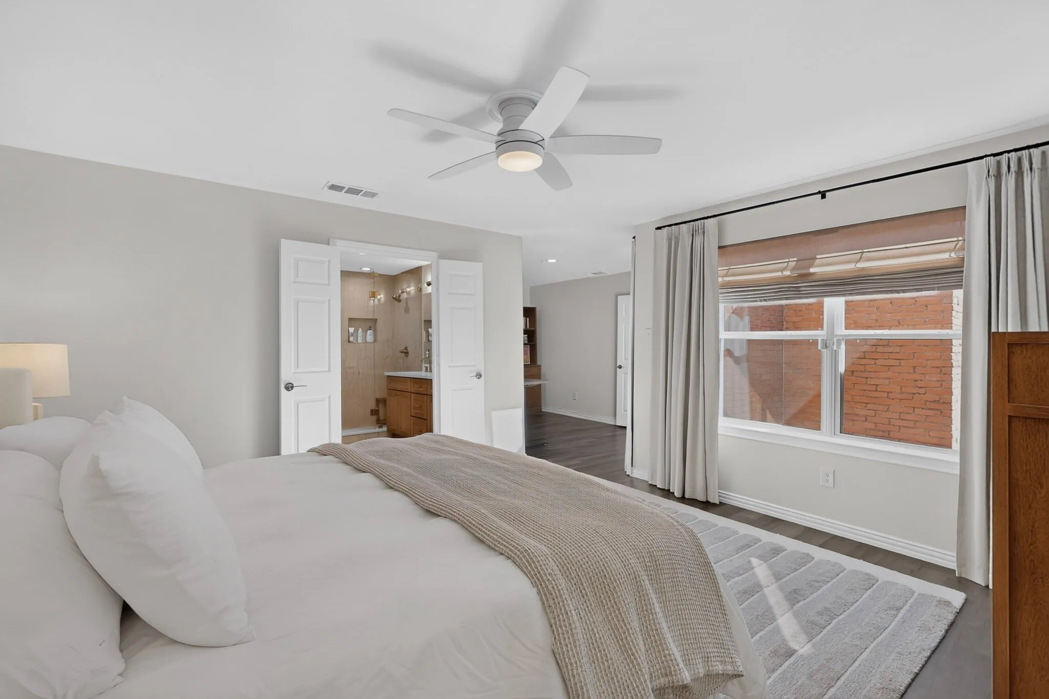 White ceiling fan, wood-finish flooring, and white window frames
