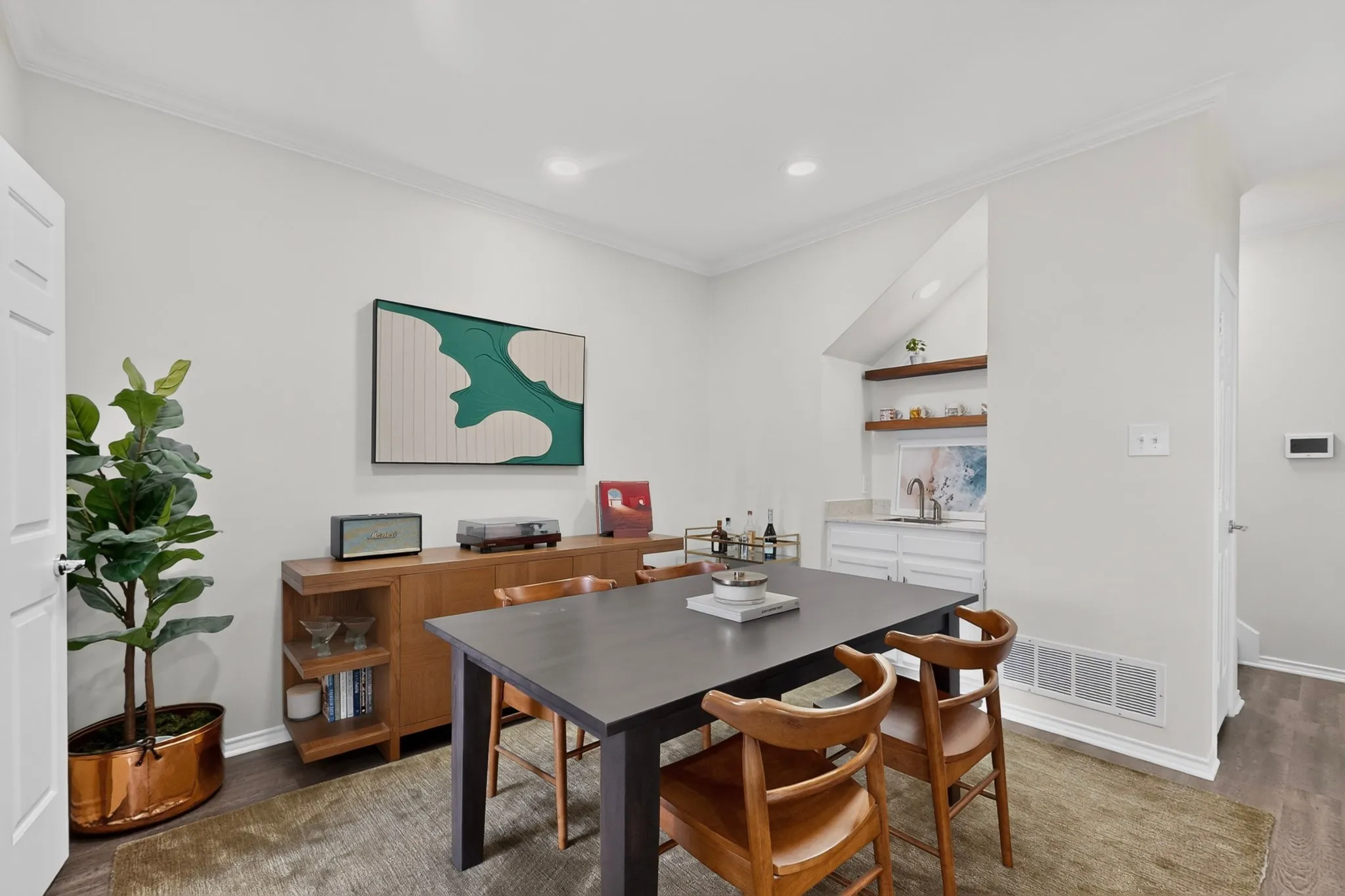 Recessed lighting, crown molding, wood-finish flooring, built-in wet bar with shelving, white cabinetry
