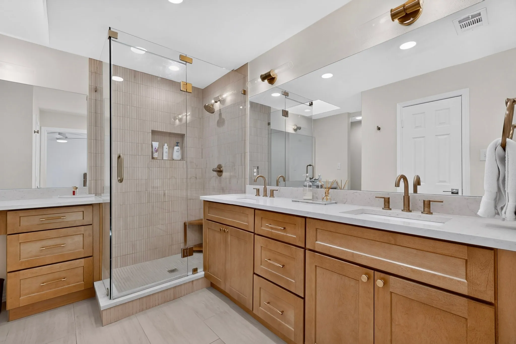 Dual vanity with integrated sinks, quartz countertops, and brushed brass fixtures