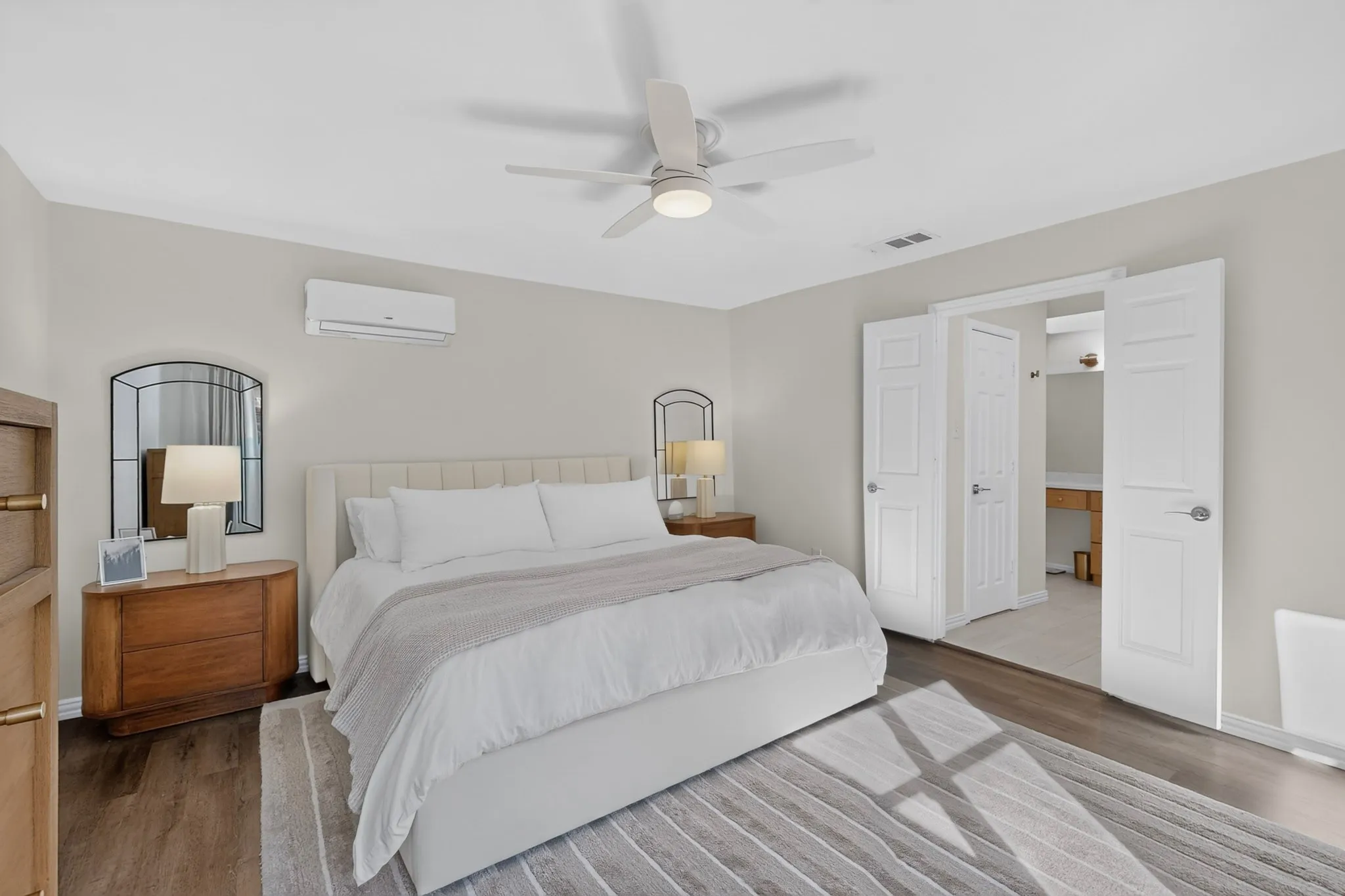 Wood-finish flooring, ceiling fan, split air conditioning unit, and double-door entry