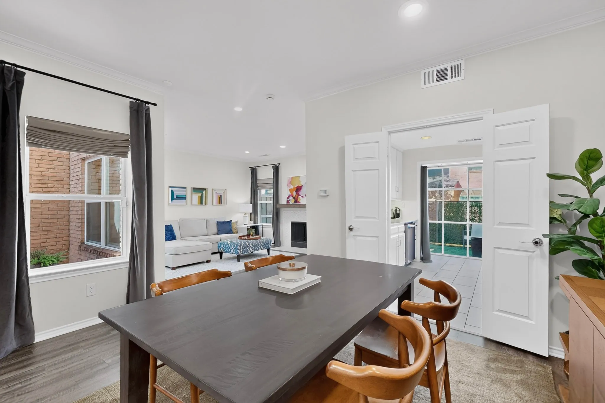 Hardwood-finish flooring extending through living spaces, crown molding, recessed lighting, and white paneled doors