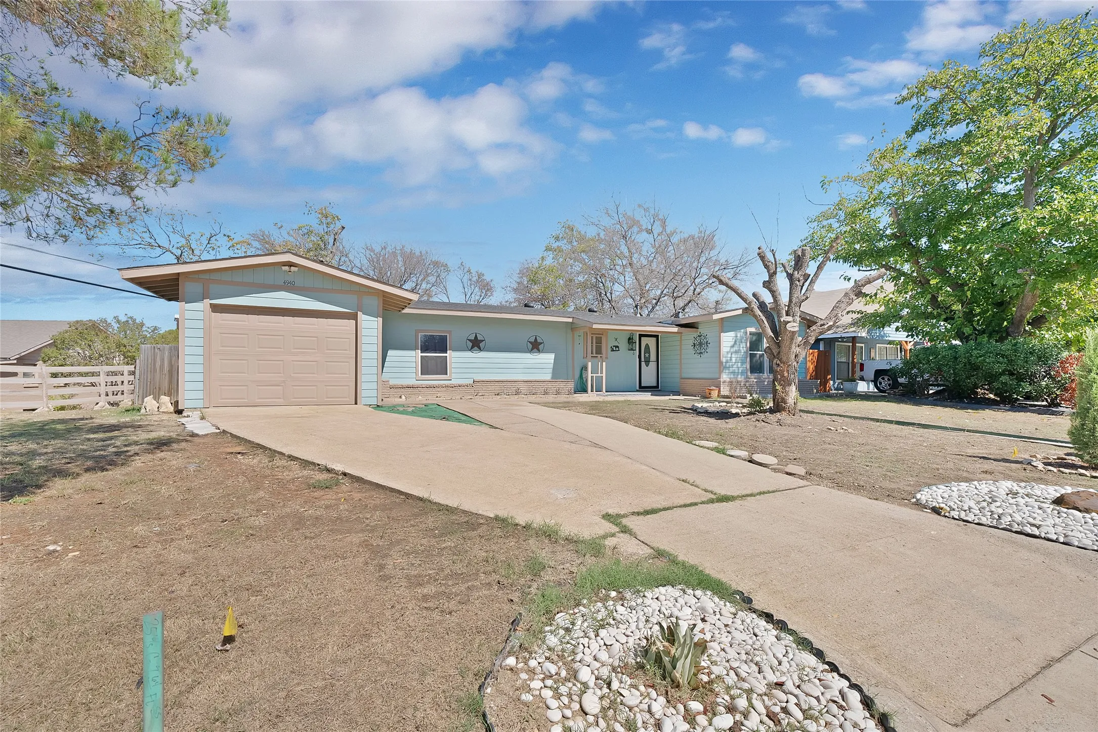Single-story residence featuring a one car garage, light blue siding, and a concrete driveway