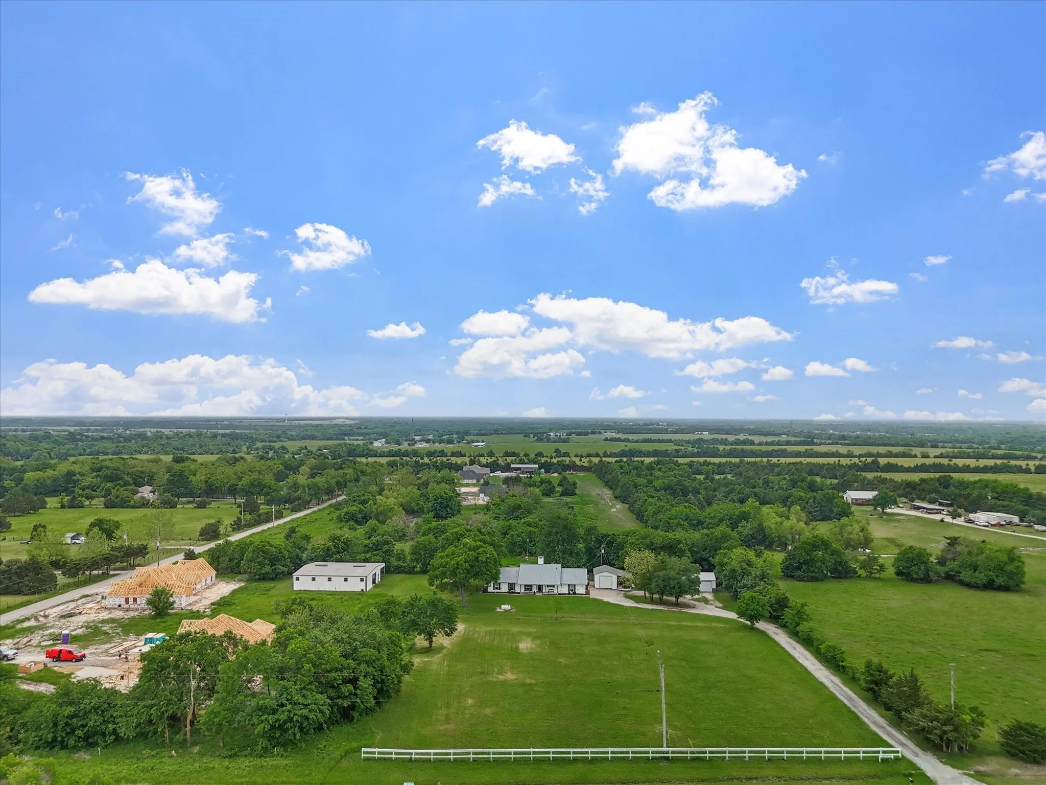 Sprawling rural estate set on expansive grounds with mature landscaping and lush pastures