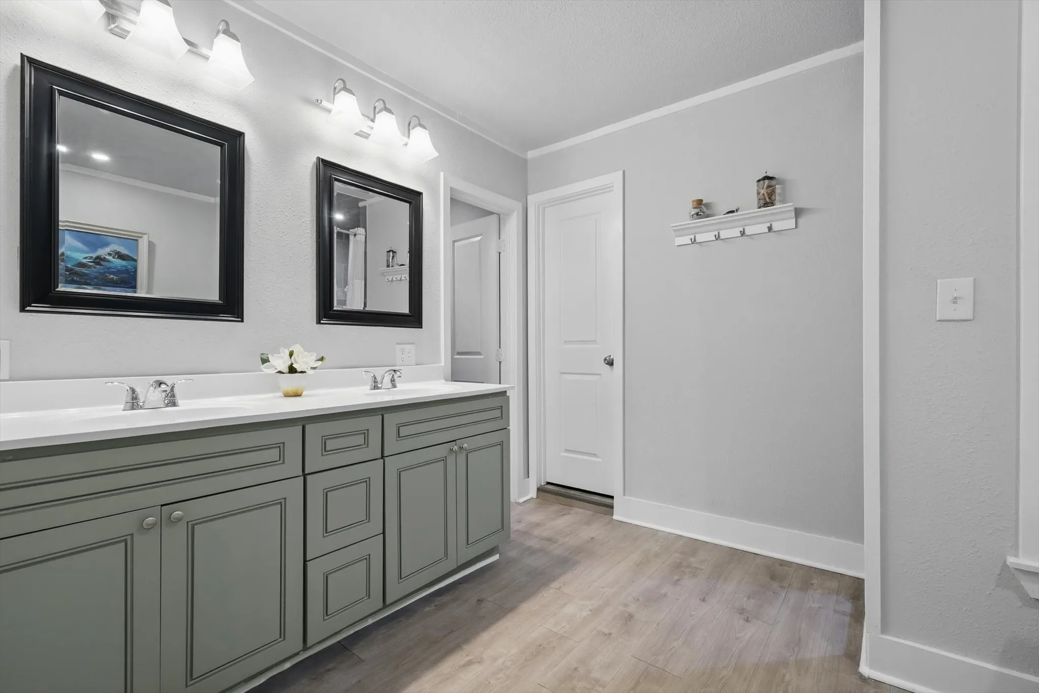 Double vanity with dual undermount sinks, gray shaker-style cabinetry, and wood-finish flooring