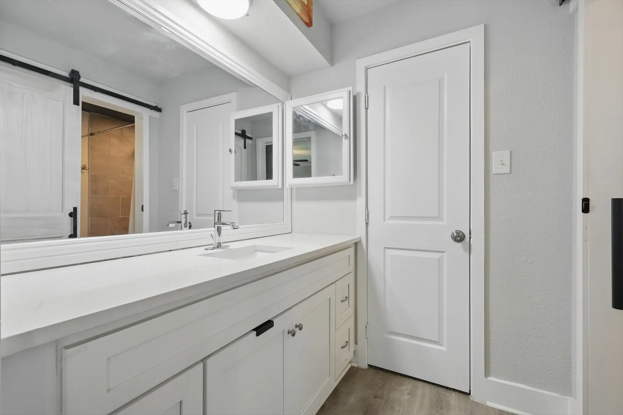 White vanity featuring a single-basin sink, chrome faucet, and white countertop