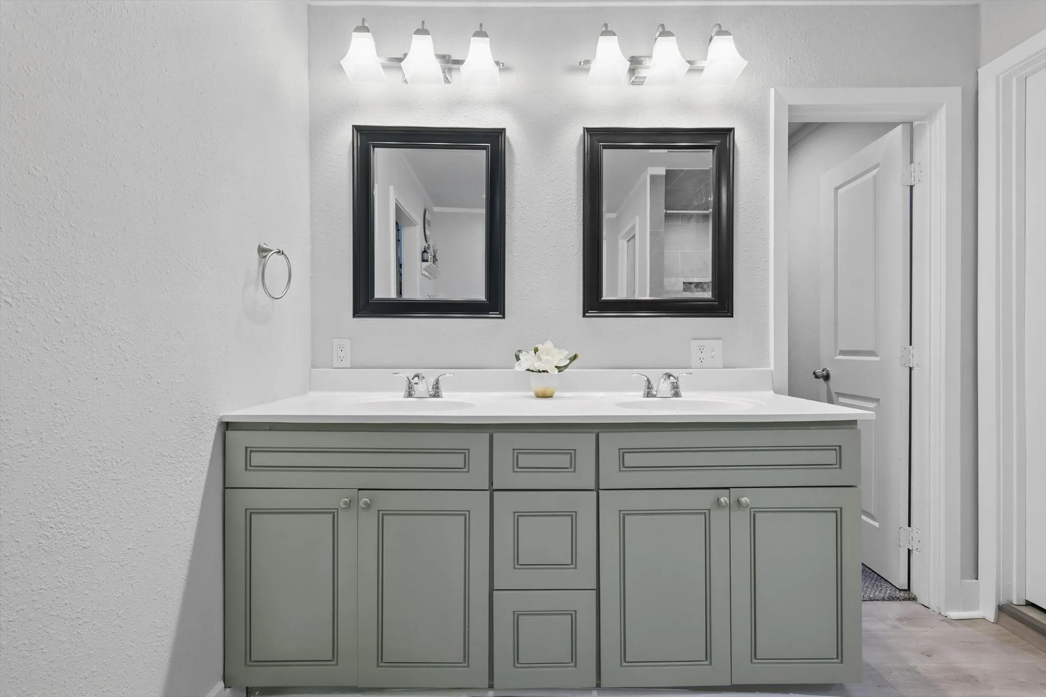 Dual-sink vanity with soft-close cabinetry in sage-finish wood, white quartz countertop, and polished chrome fixtures