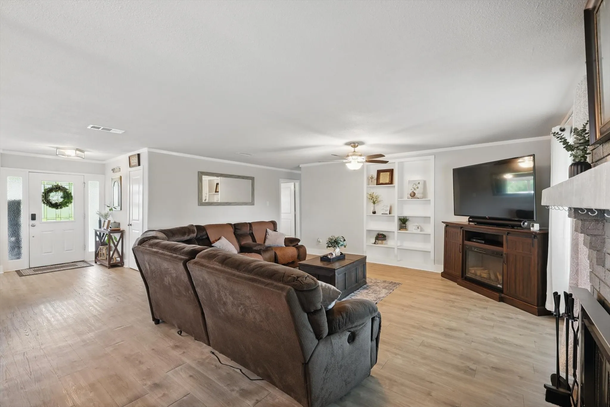 Wood-finish flooring, white trim, recessed lighting, ceiling fan, and built-in shelving