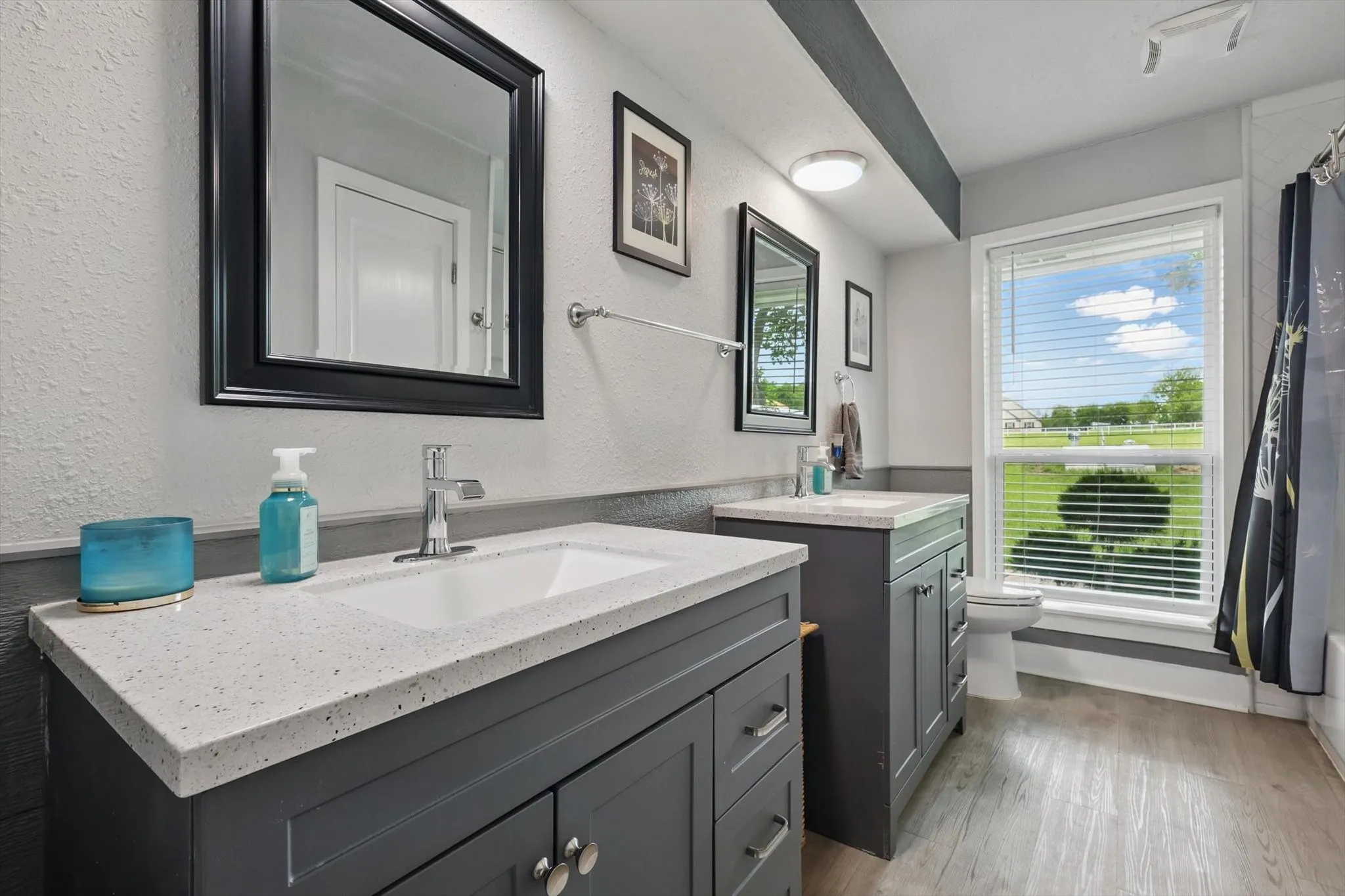 Dual vanities with integrated sinks, light-toned countertops, and dark cabinetry