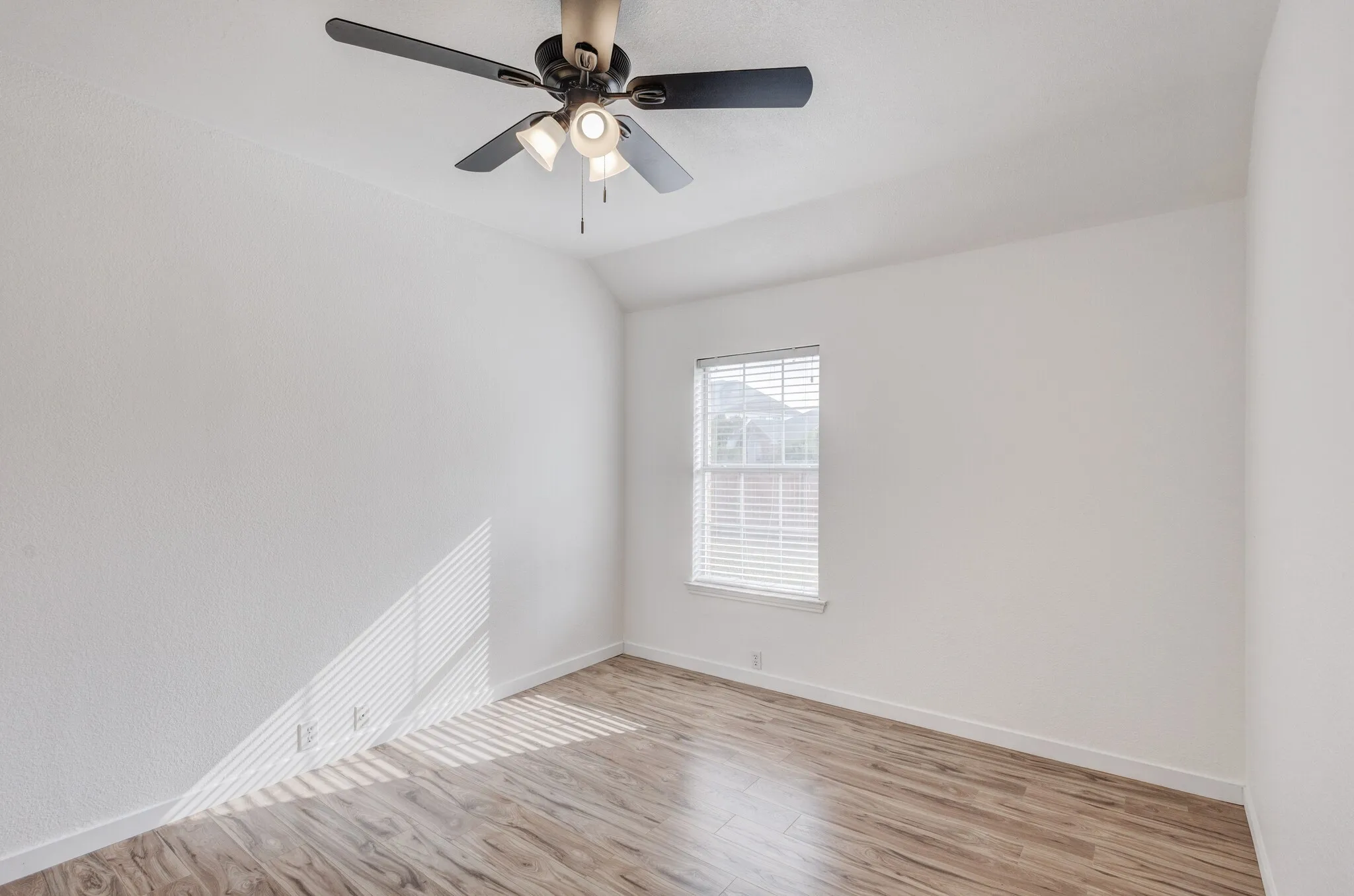 Unfurnished room with vaulted ceiling, light hardwood / wood-style flooring, and ceiling fan
