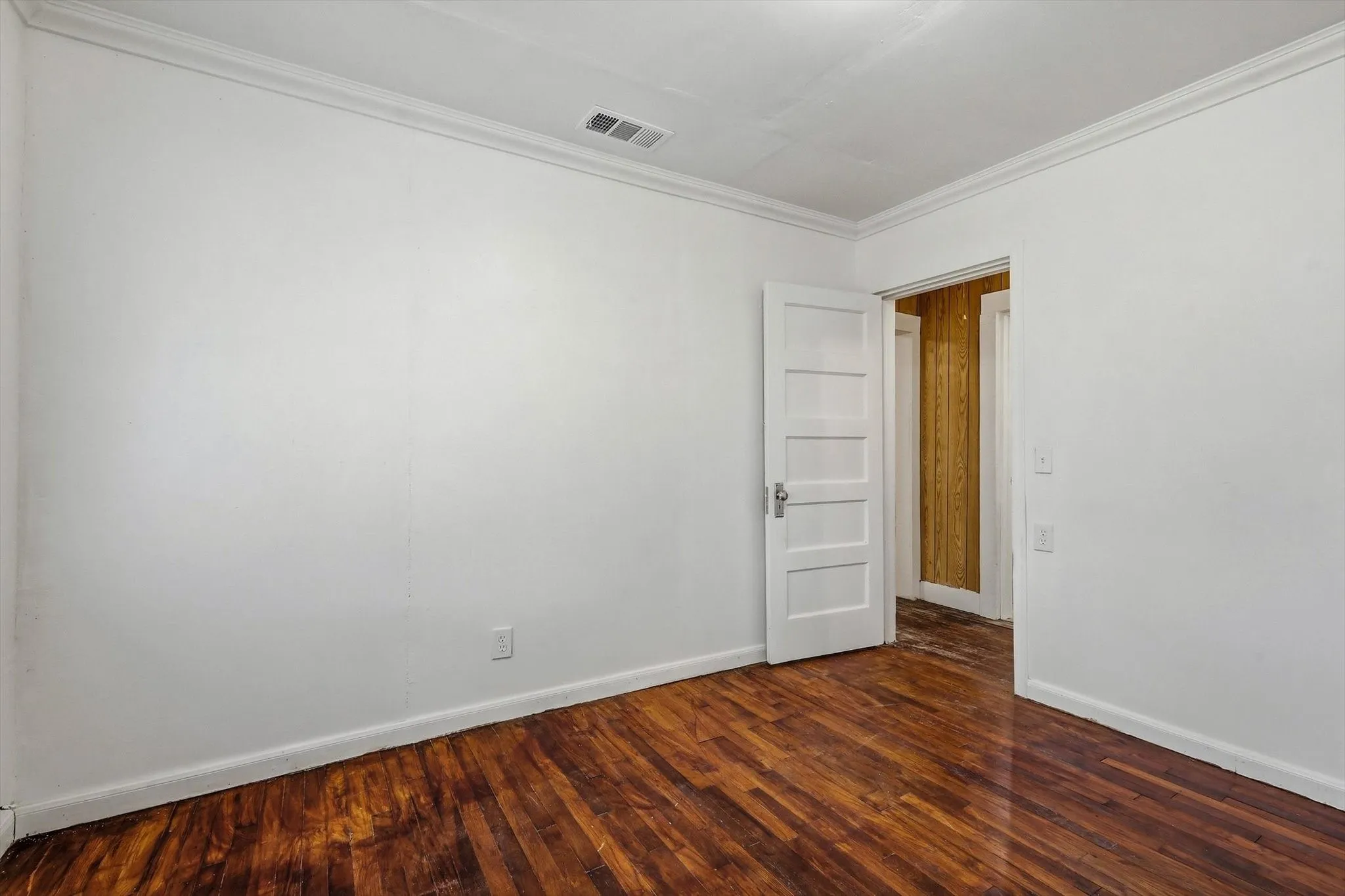 Hardwood flooring with a glossy finish and white trim