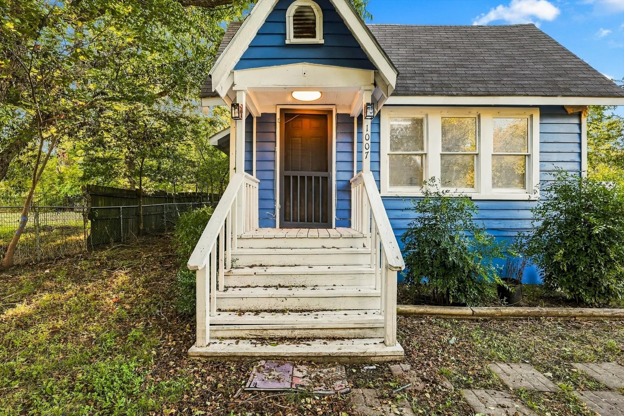 Blue exterior siding, white trim, white porch railings, front porch light fixture, and visible house​​‌​​​​‌​​‌‌​‌‌​​​‌‌​‌​‌​‌​​​‌​​ number