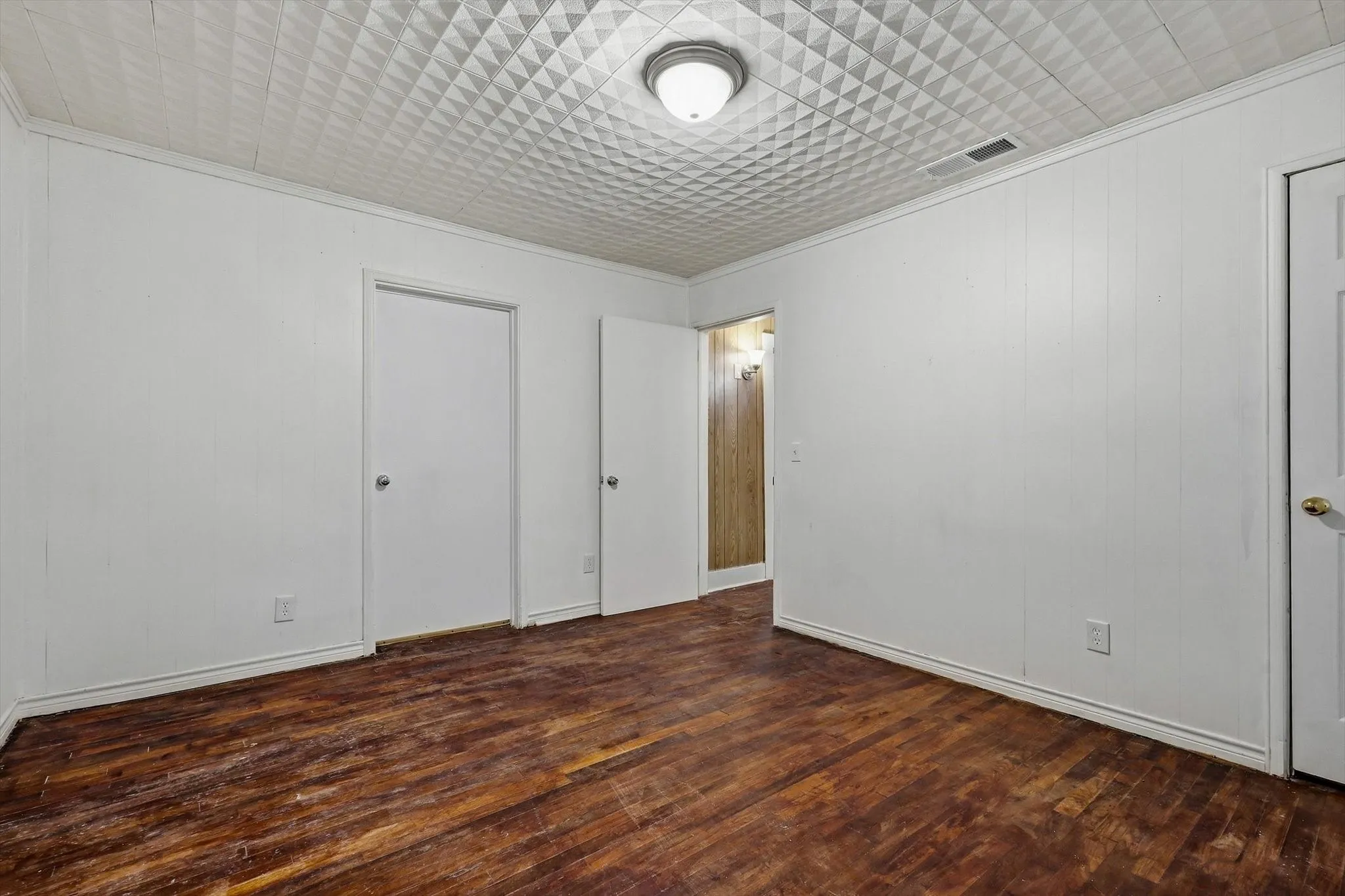 Wood-finish flooring with white wall paneling