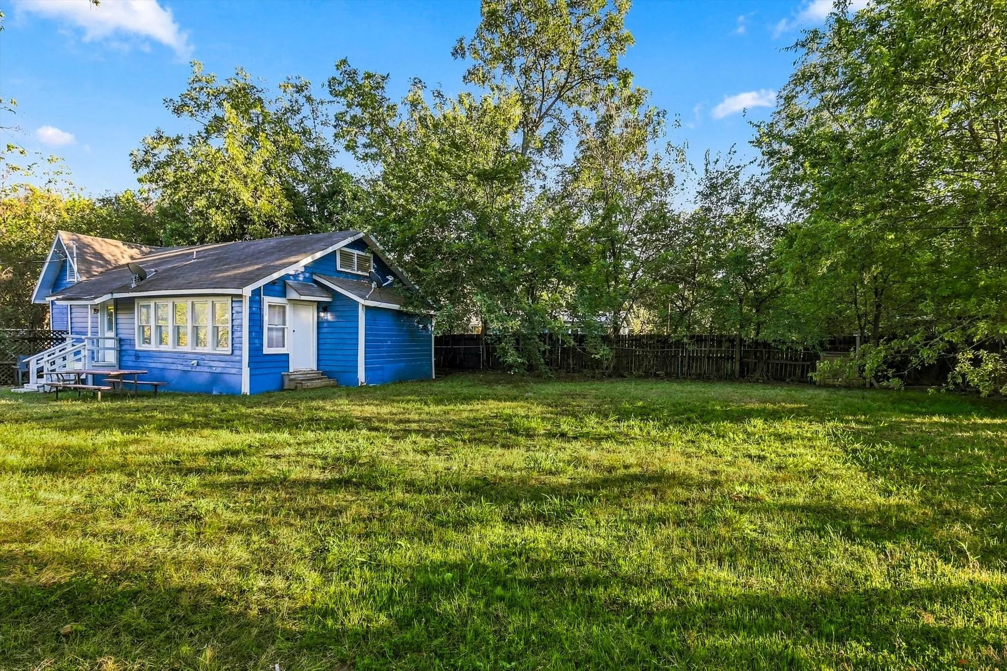 Expansive grassy yard with mature perimeter trees