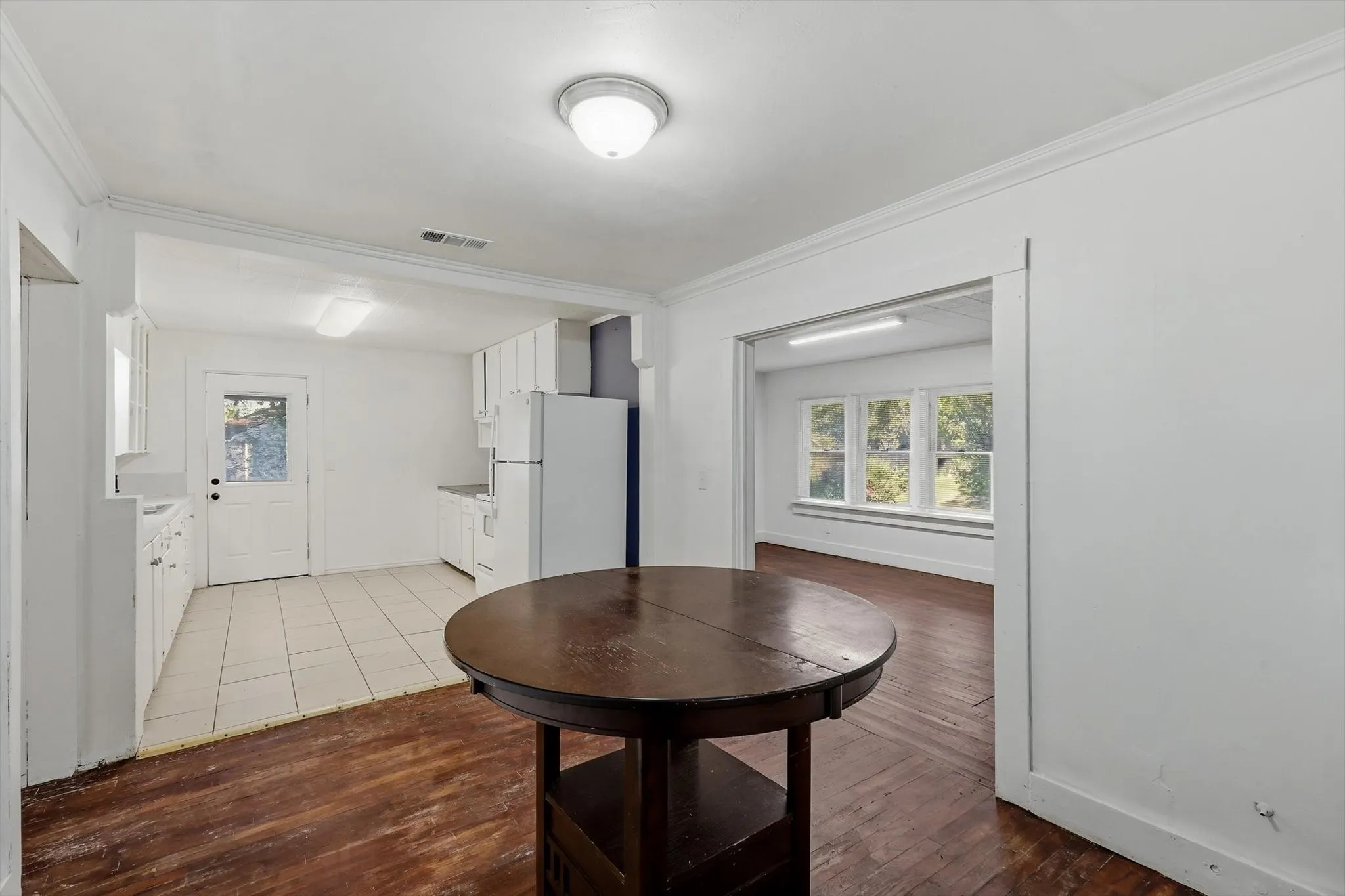 White kitchen cabinetry with tile flooring