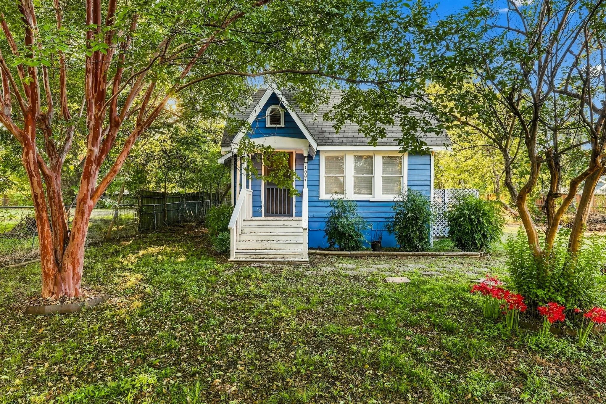 Charming cottage-style home featuring a light blue exterior with white trim and gabled roofline
