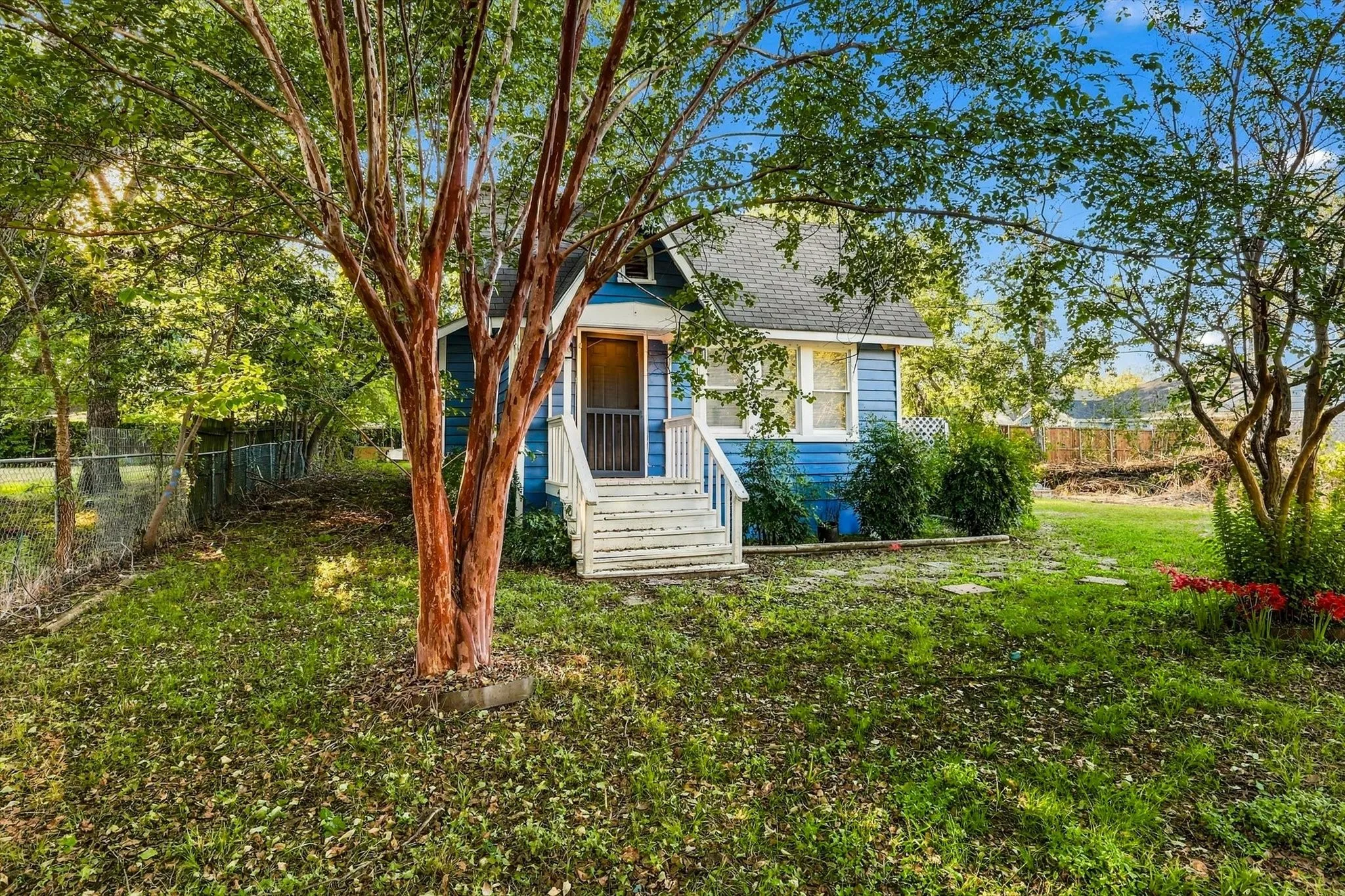 Blue clapboard siding exterior with white trim, a gabled roof, and a white-railed front porch