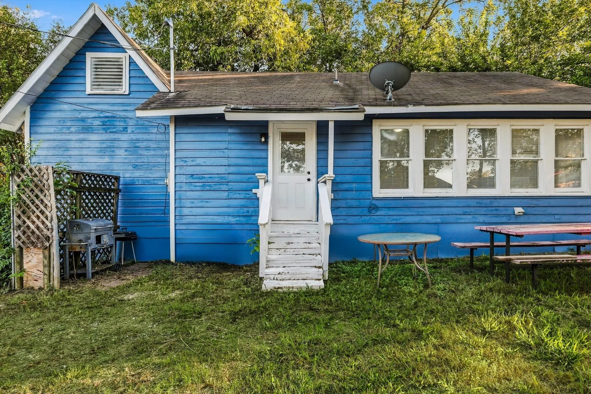 Blue horizontal siding exterior with white trim and multi-pane windows