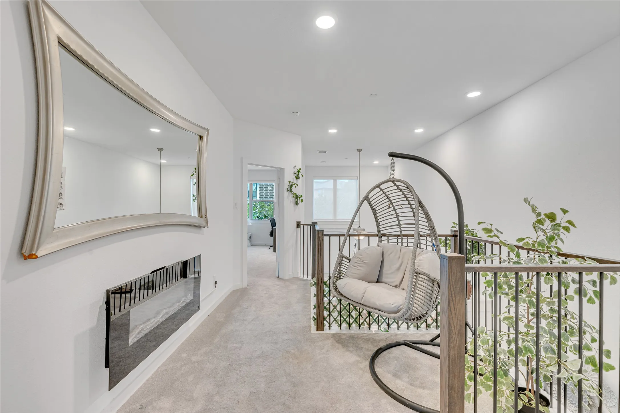 Recessed lighting, light gray carpeting, and a built-in wall-mounted fireplace