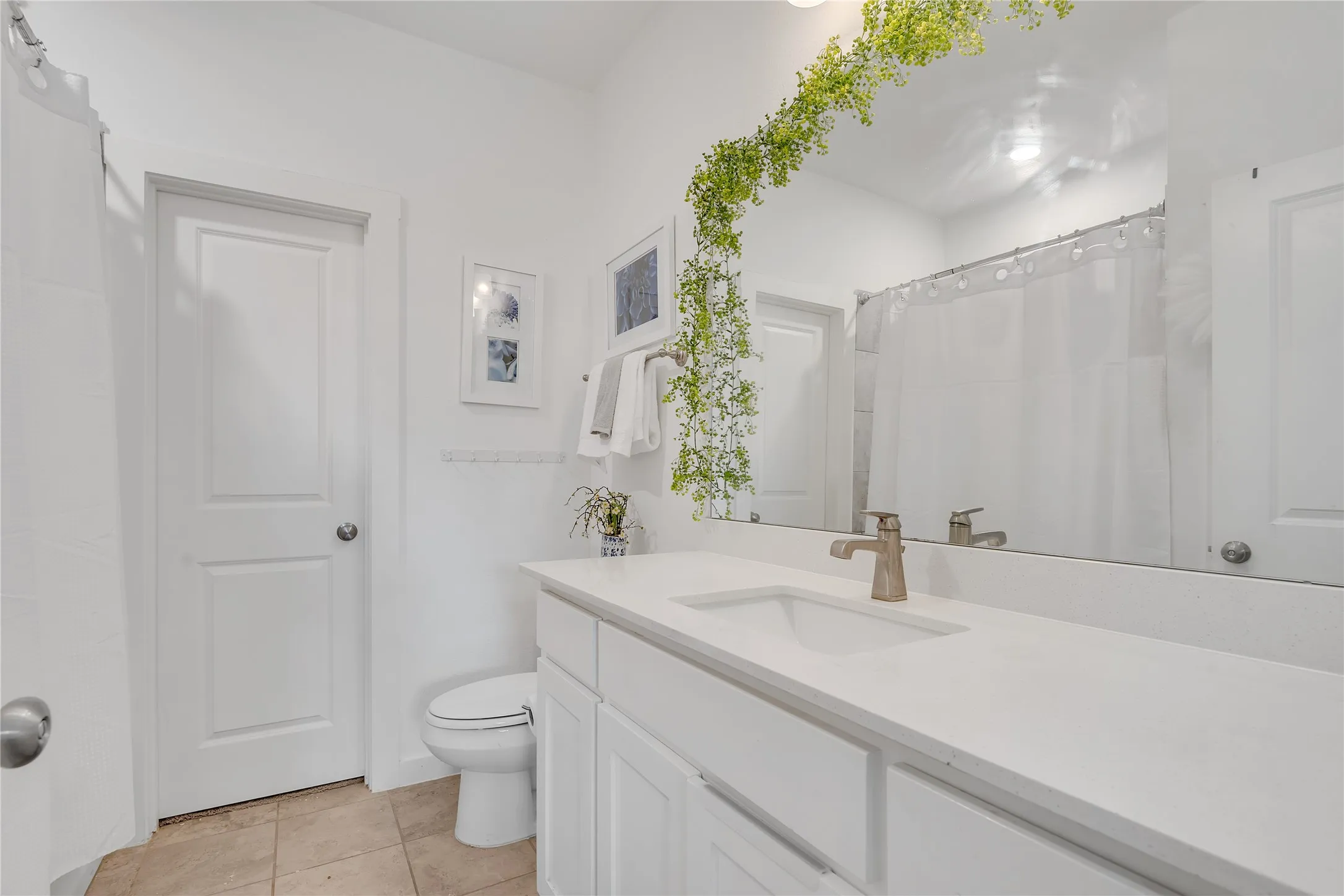 White vanity with integrated sink, quartz countertop, and brushed nickel faucet