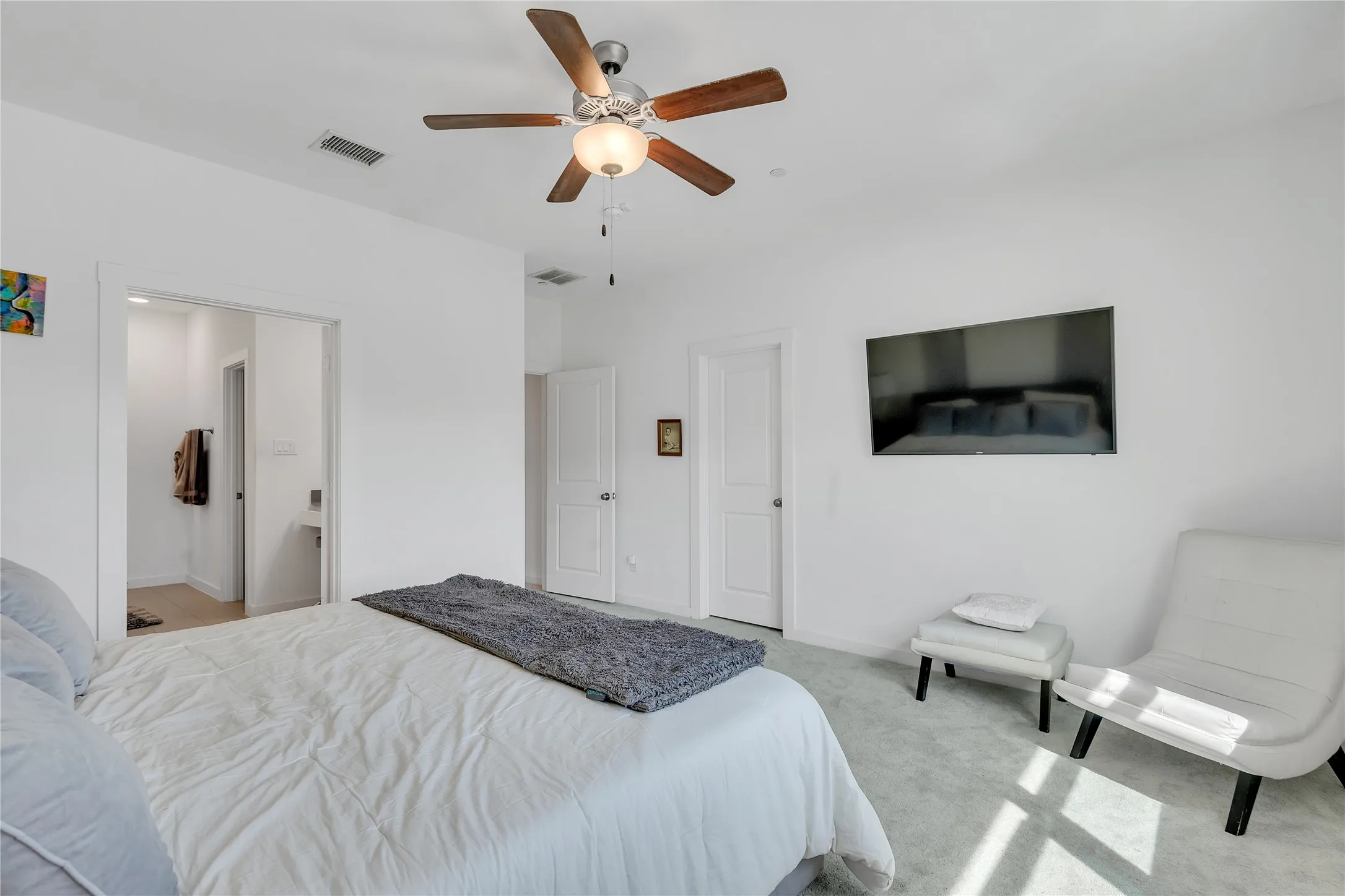 Carpeted sleeping area with ceiling fan and attached lighting fixture