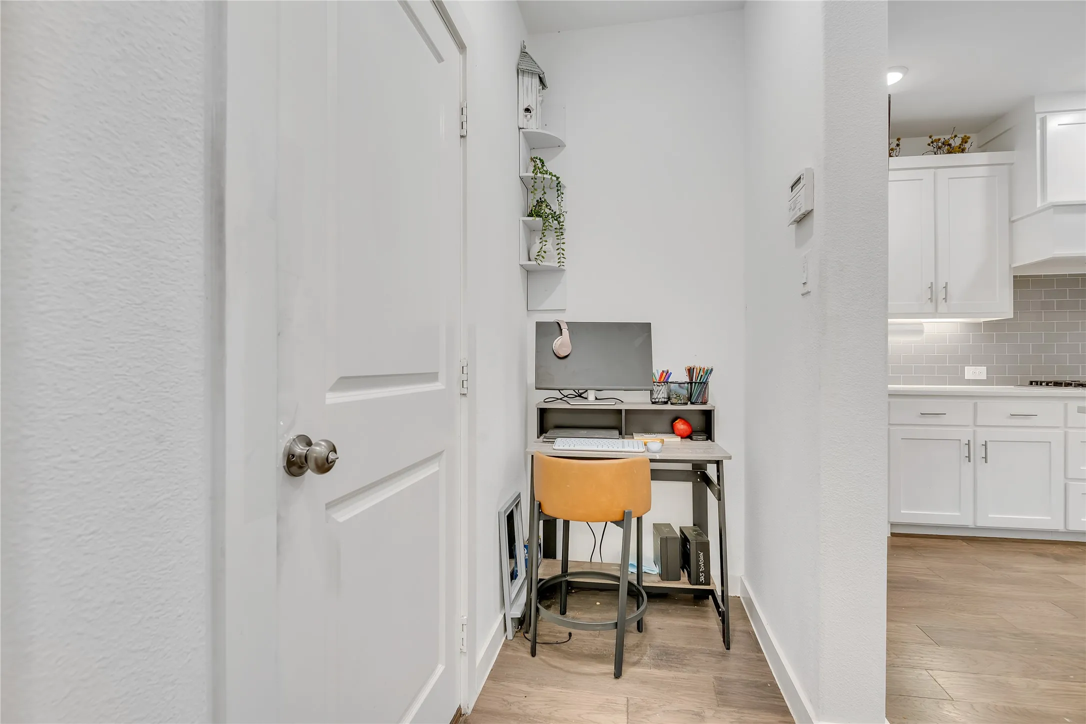 Wood-finish flooring, white walls, and a built-in shelving unit