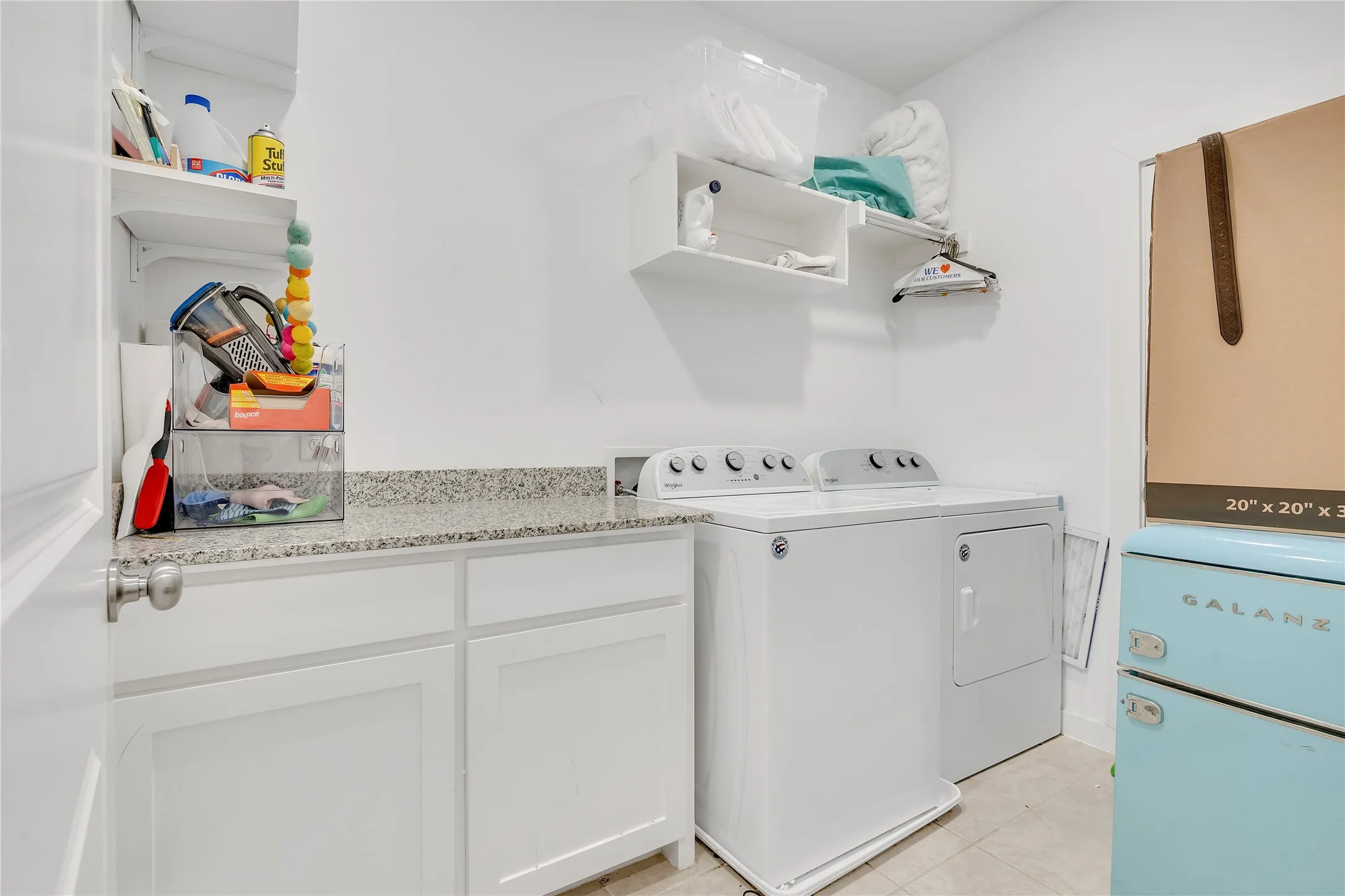 Built-in cabinetry with a light-toned countertop, and integrated shelving
