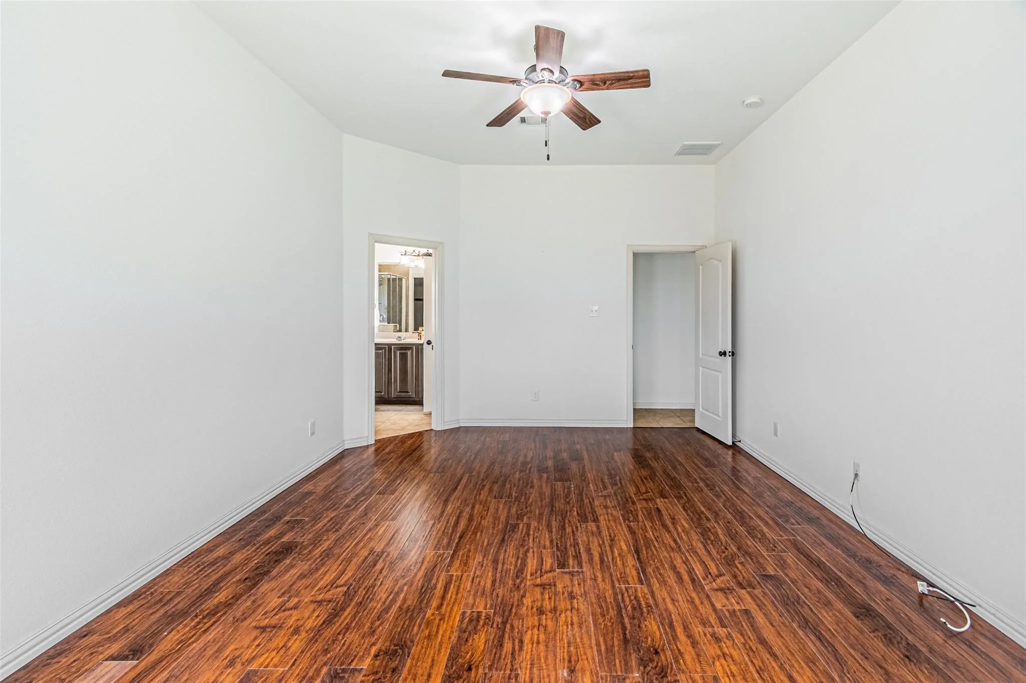 Wood-finish flooring, vaulted ceilings, and a ceiling fan with integrated lighting