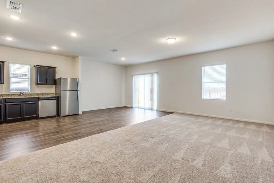 Open-concept living space featuring wood-finish flooring, recessed lighting, and a sliding glass door