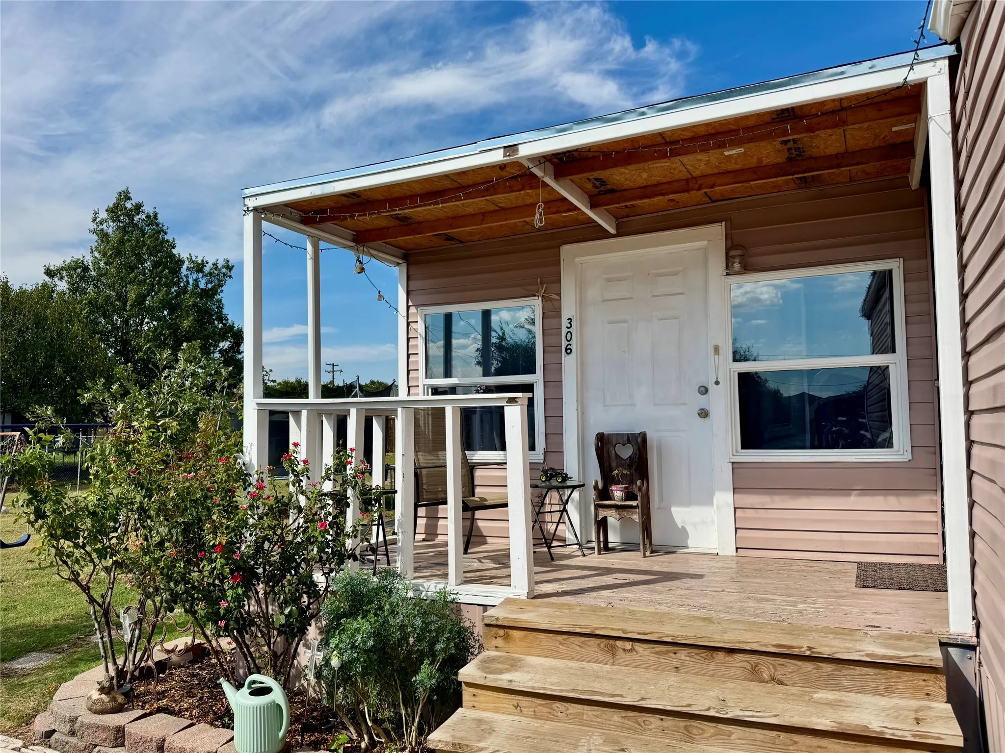 Front porch with wood steps, wood railing, and an overhead wood-finish ceiling