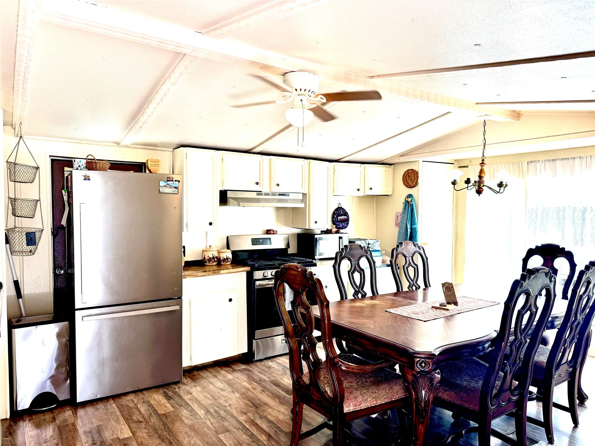 Kitchen and dining area featuring laminate wood-finish flooring and a ceiling fan