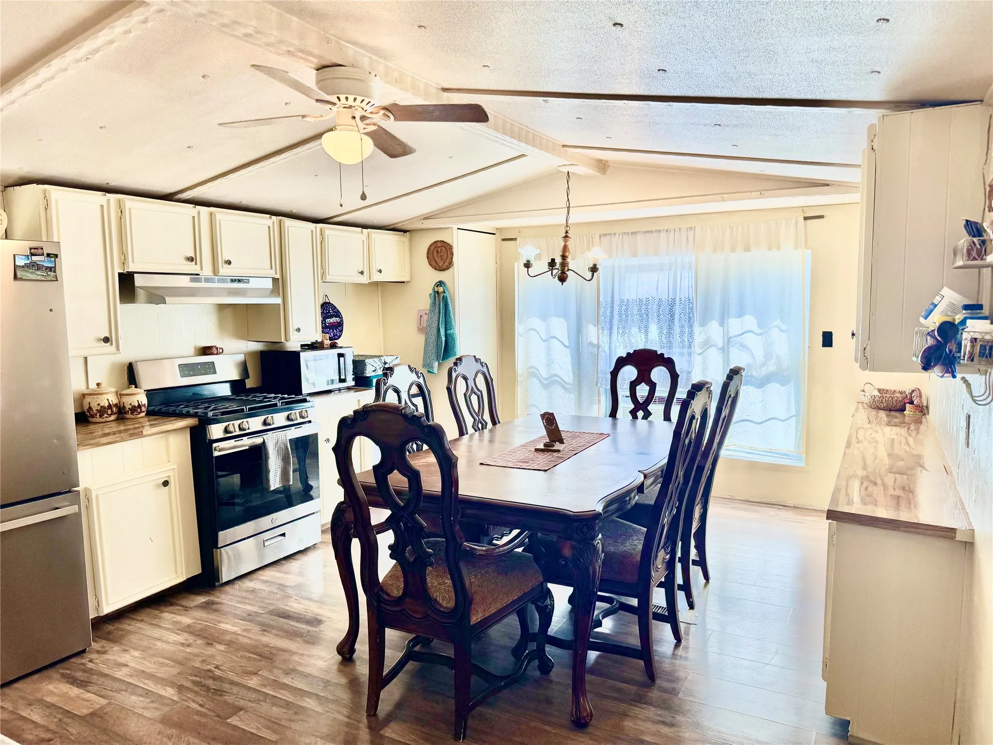 Kitchen with white cabinetry, stainless steel appliances, and a ceiling fan