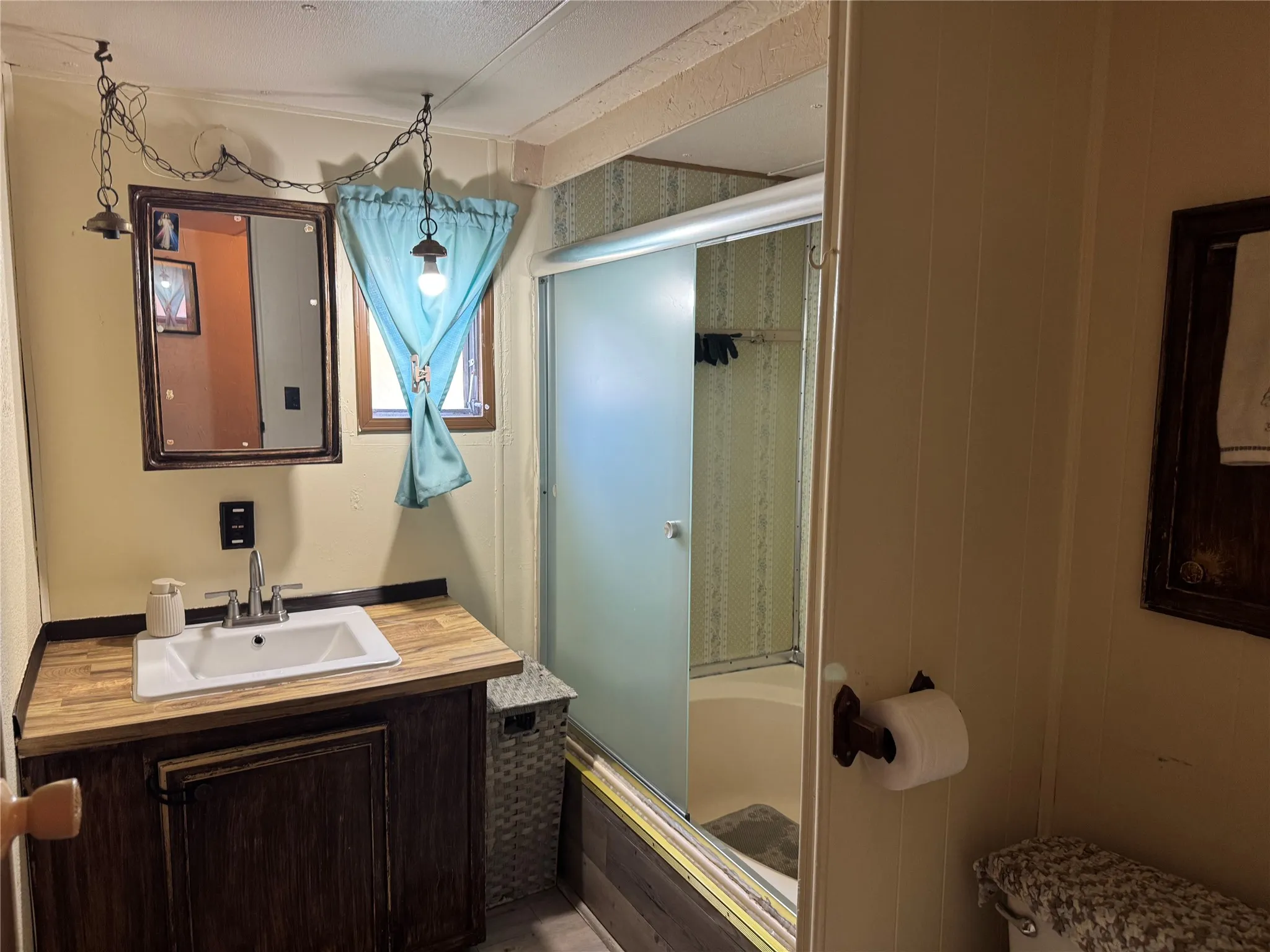 Vanity with a wood-finish countertop and dark wood-finish cabinetry