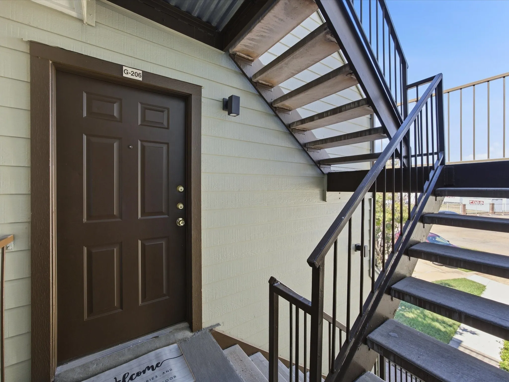 Panel door entry with a wall-mounted exterior light fixture