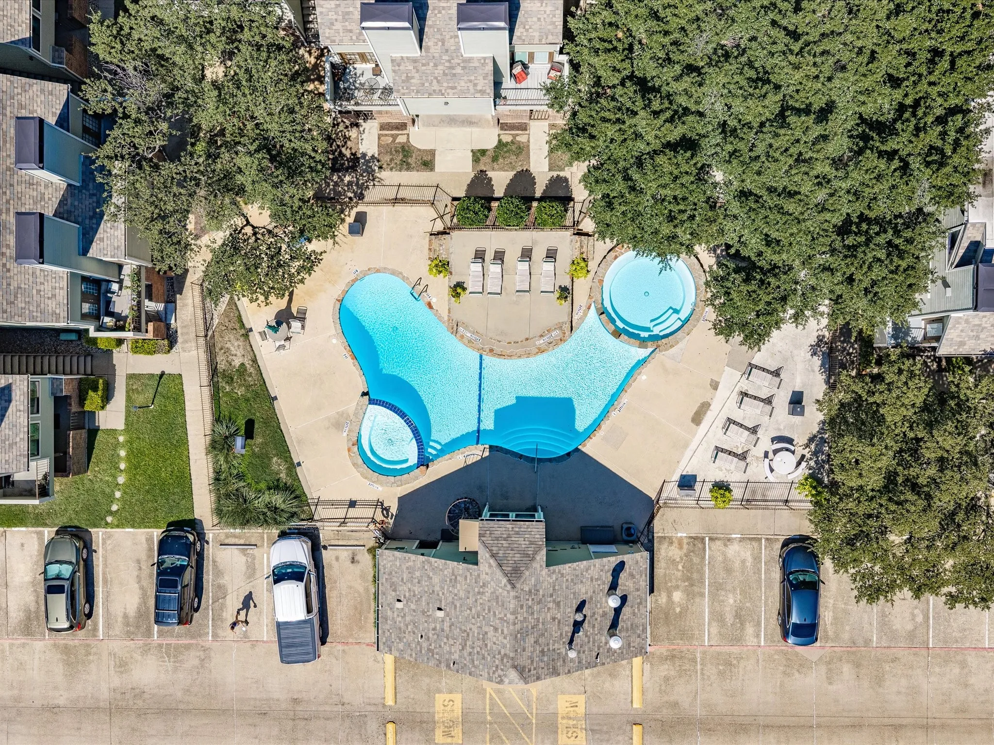 Expansive common area featuring a multi-level swimming pool, integrated spa, and shaded lounging areas