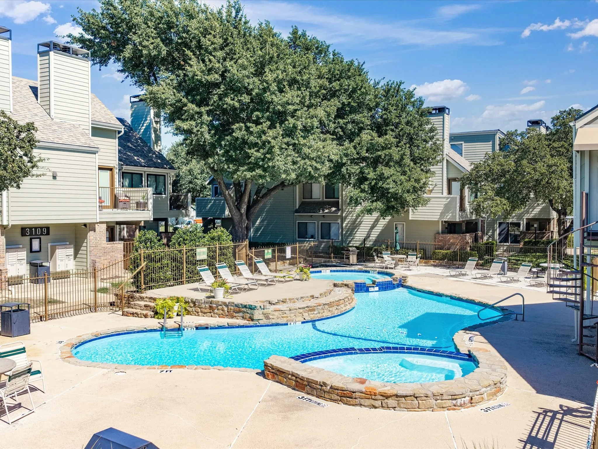 Resort-style pool with integrated spa and stone-clad surround