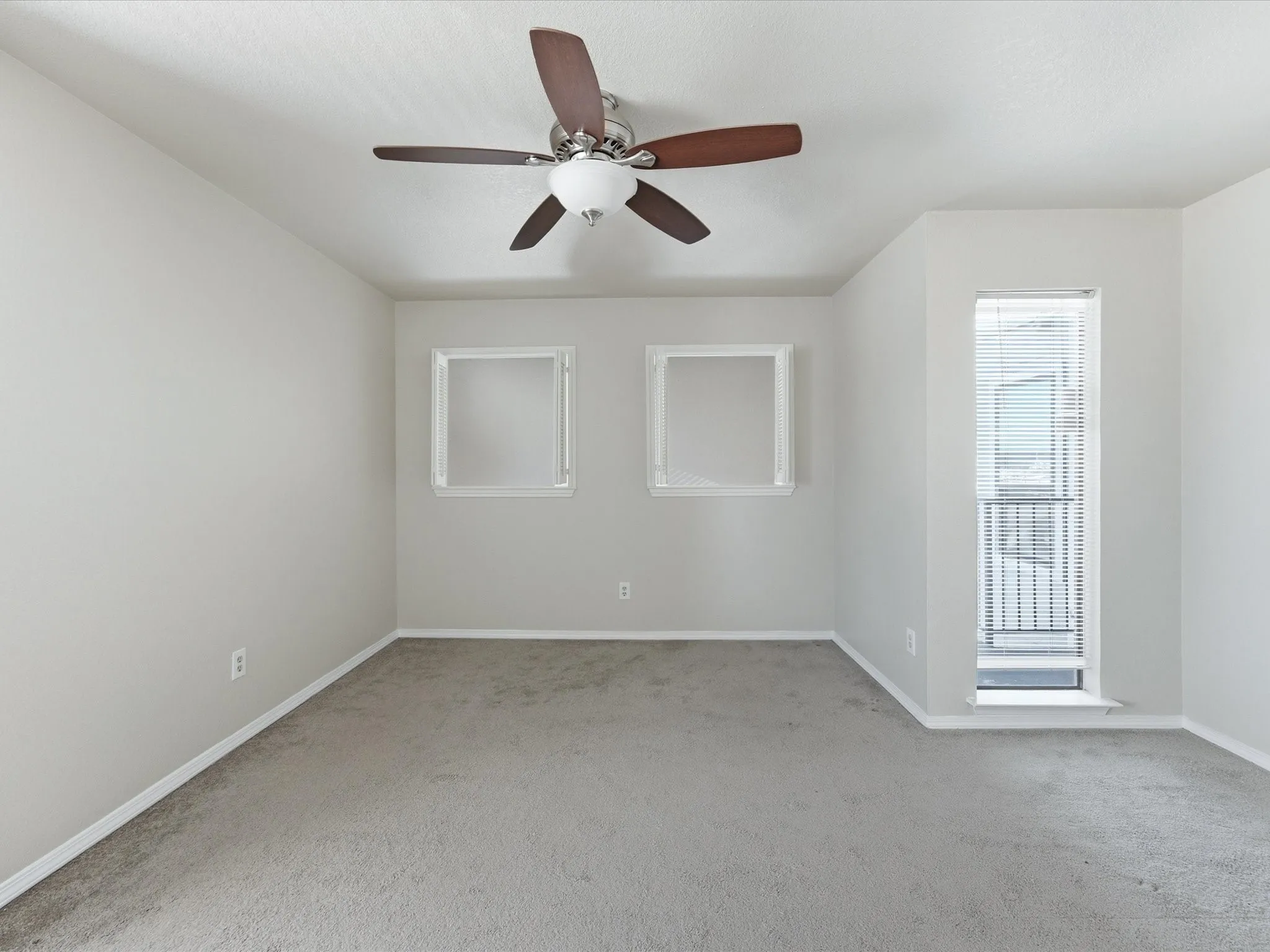 Recessed windows, ceiling fan with light fixture, and carpeted flooring