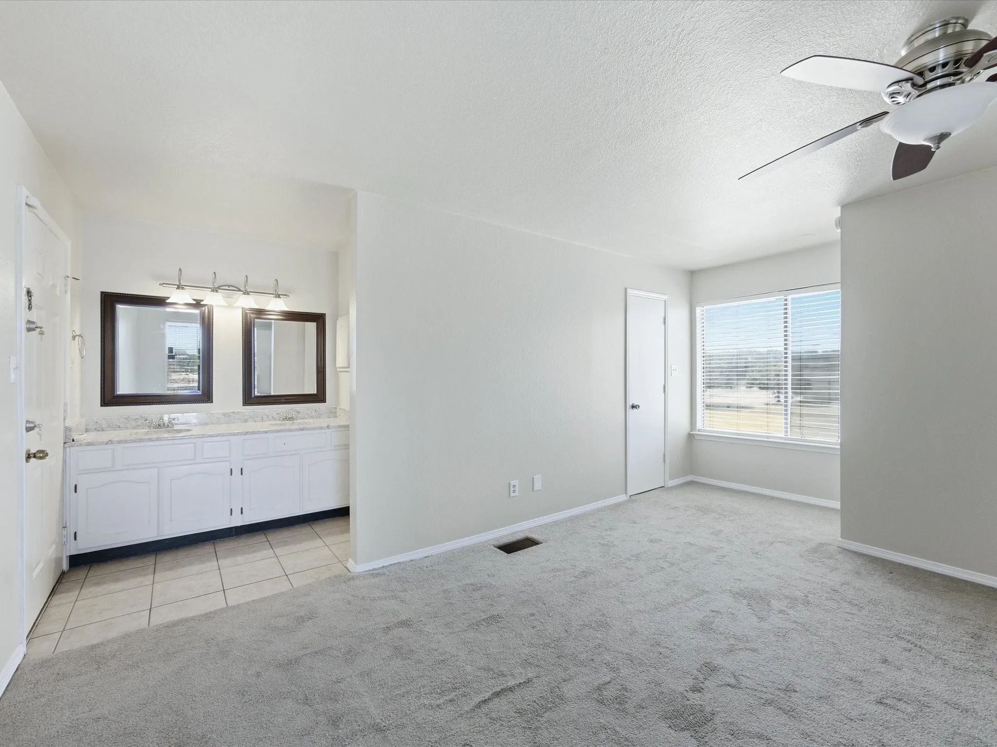 Vanity area with dual framed mirrors, white cabinetry, and a light-colored countertop
