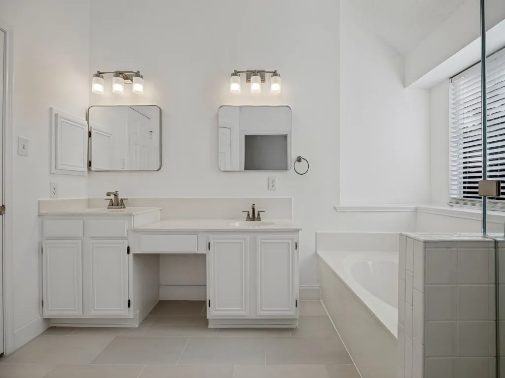 Updated primary bathroom with dual sinks and frameless glass shower