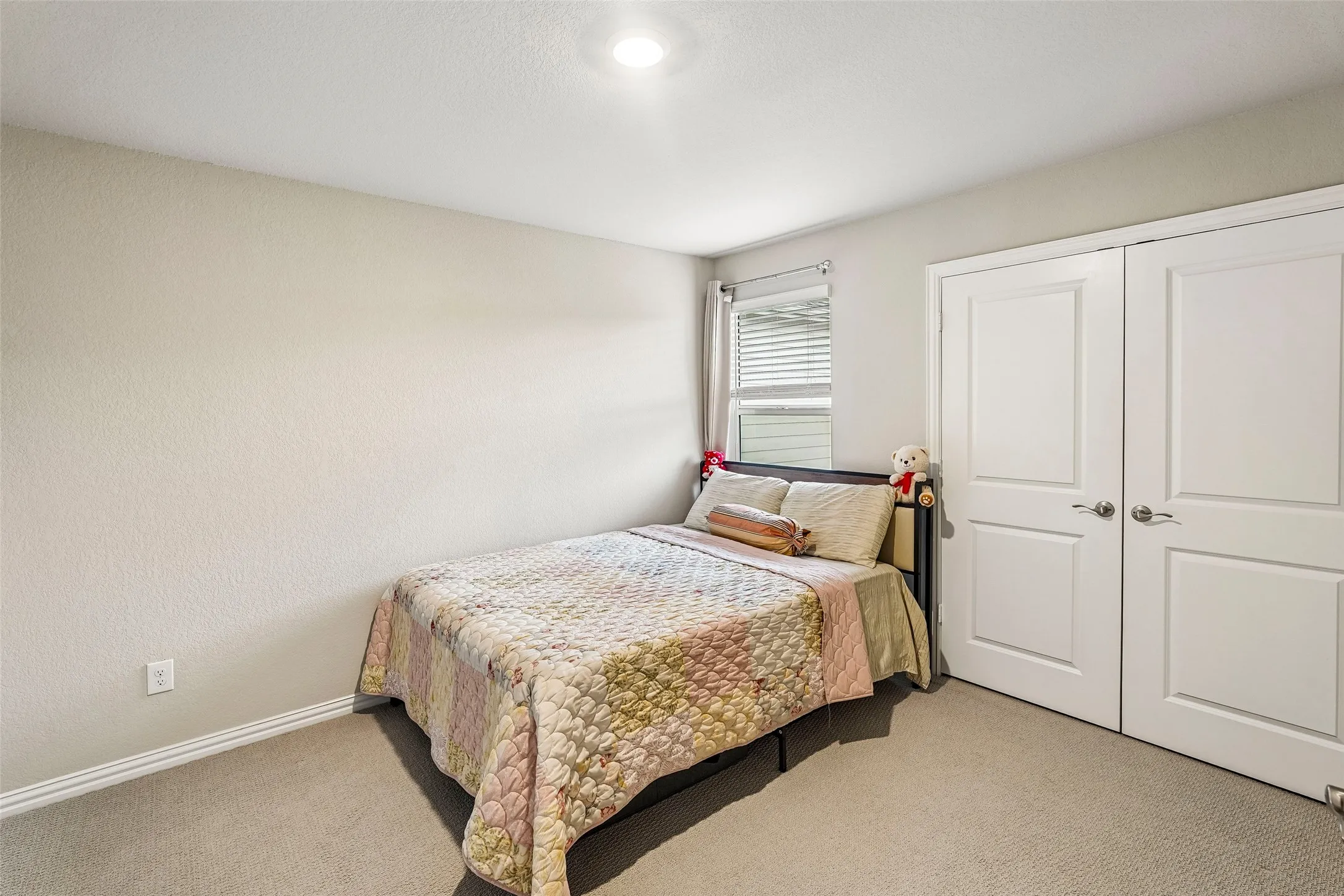 Recessed lighting, light-colored carpeting, and a window with blinds
