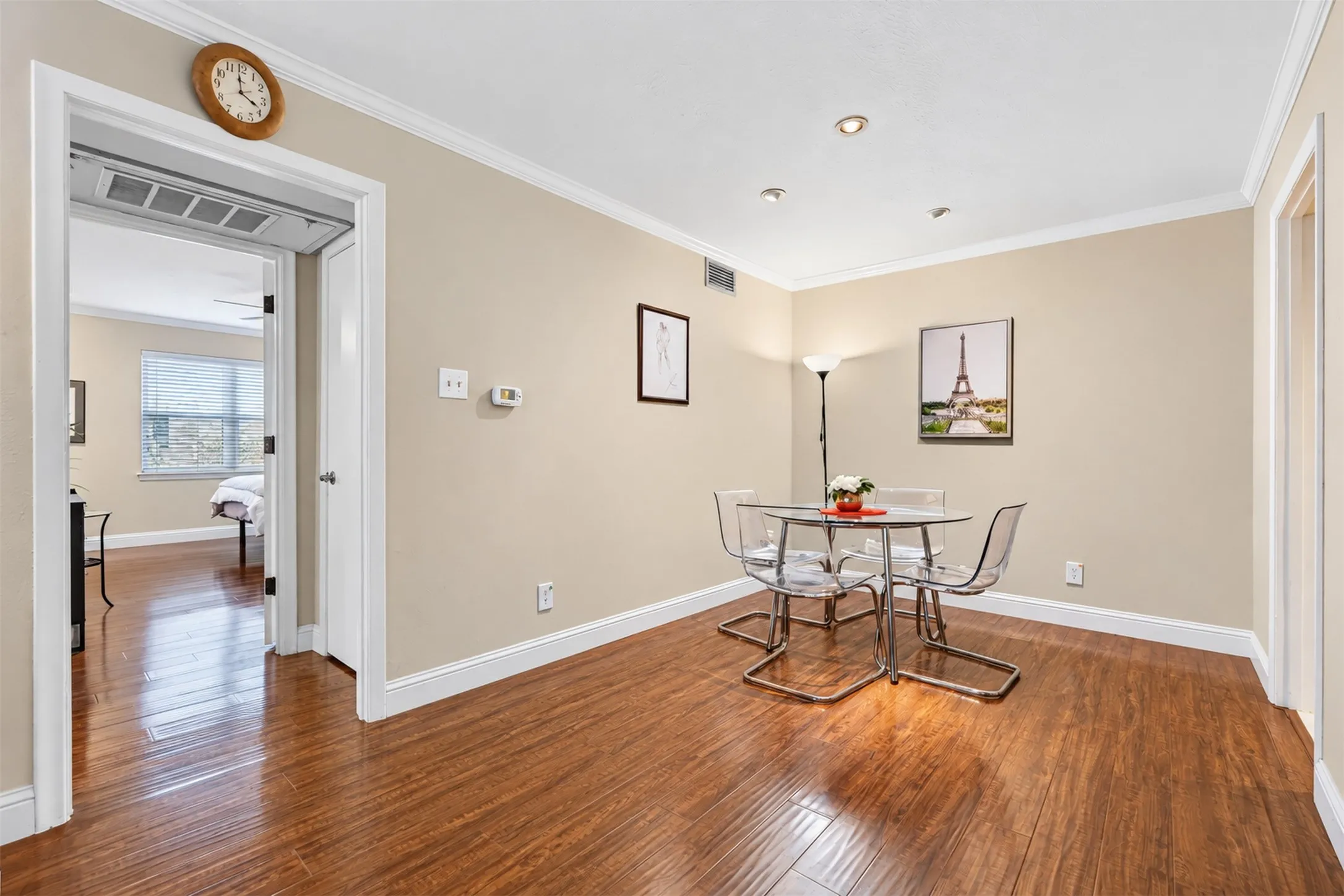 Wood-finish flooring throughout, crown molding, recessed lighting, and a neutral color palette