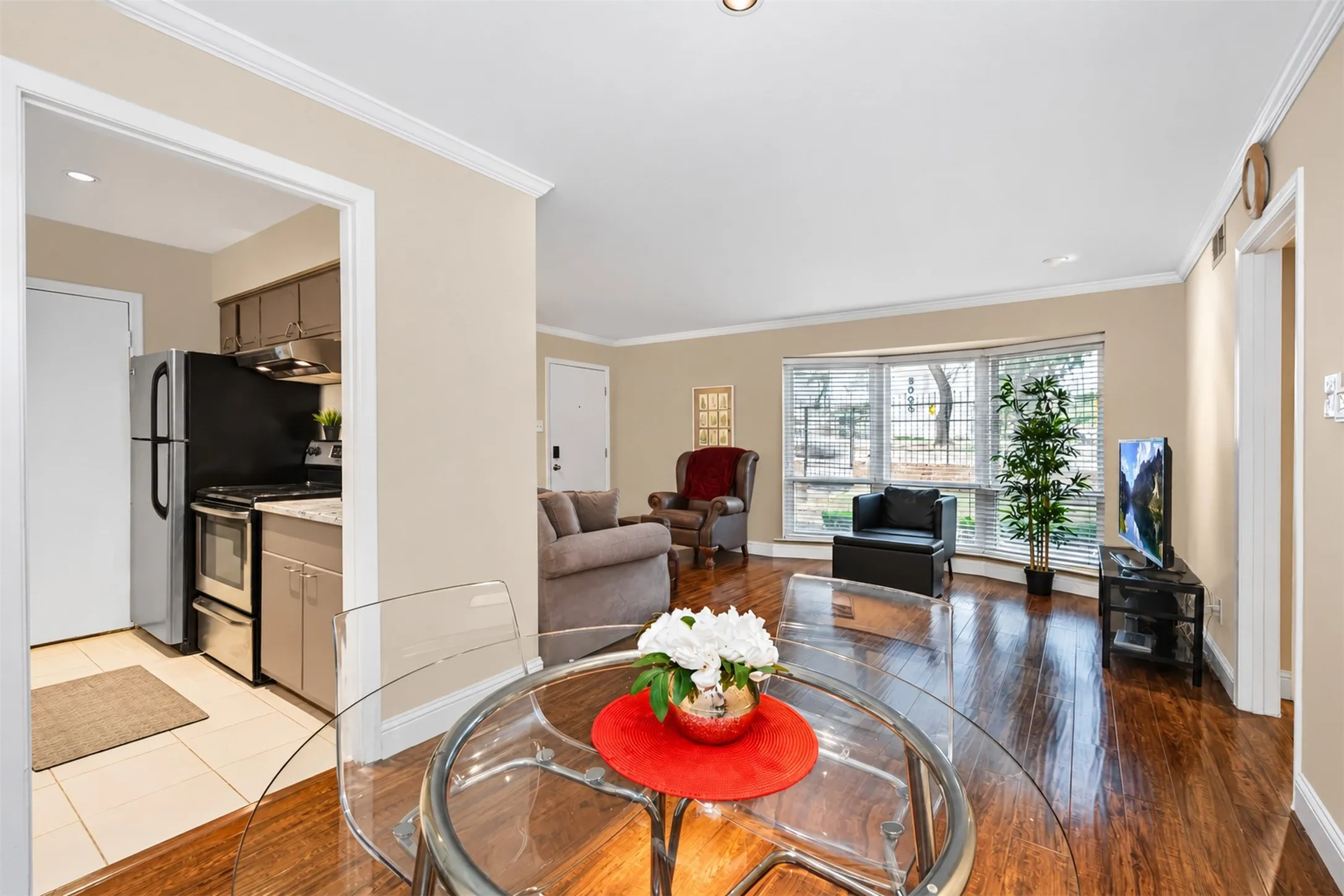Hardwood-finish flooring, coved ceilings, and a bay window in the living area