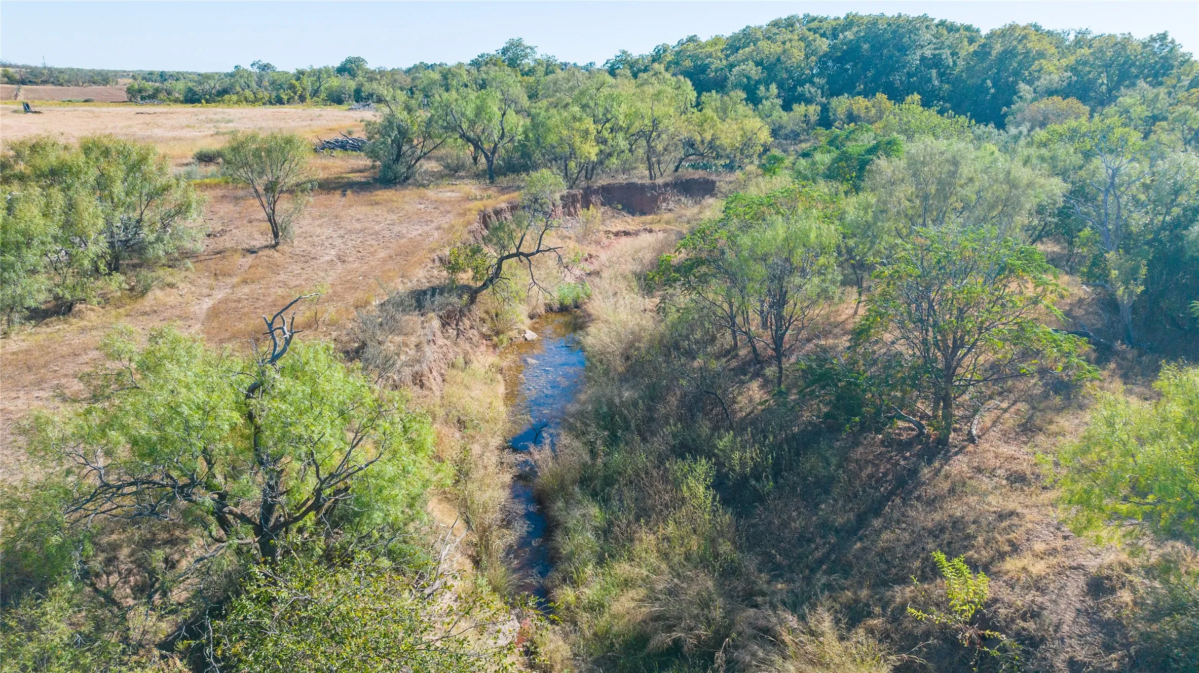 Natural water feature with surrounding vegetation and varied terrain