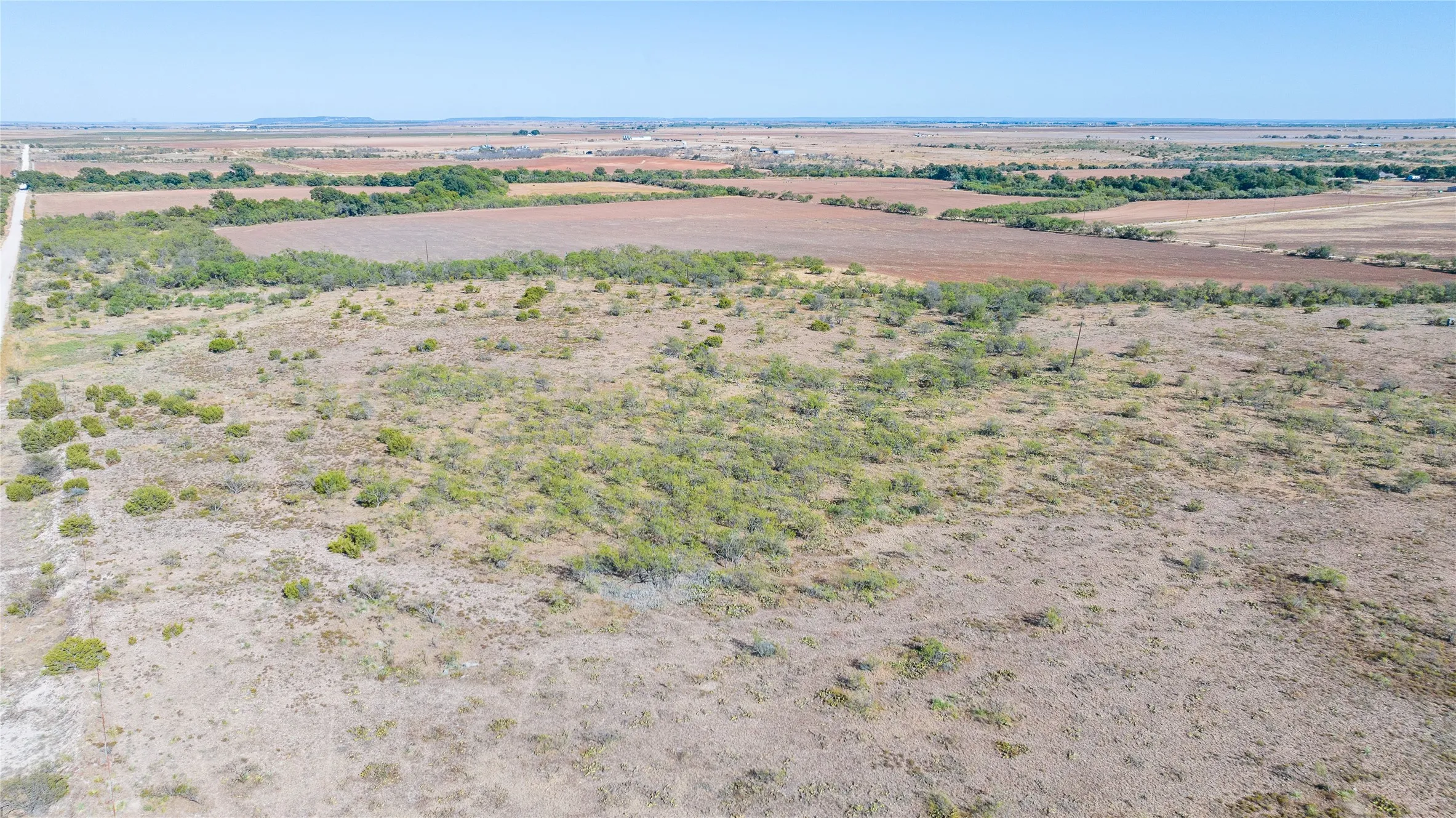 Expansive rural landscape featuring a mix of cleared land and natural vegetation