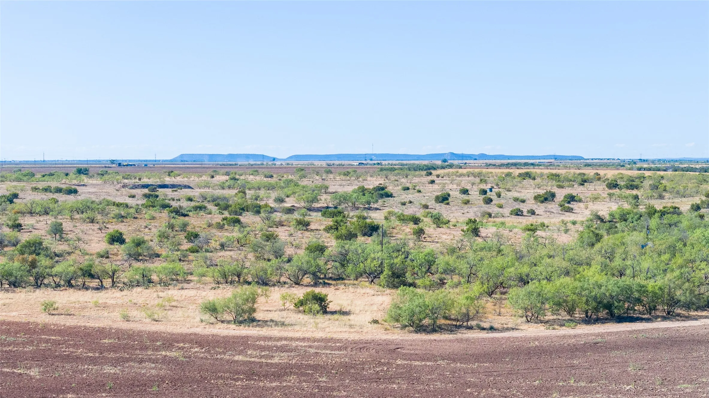 Expansive landscape featuring natural vegetation and distant landforms