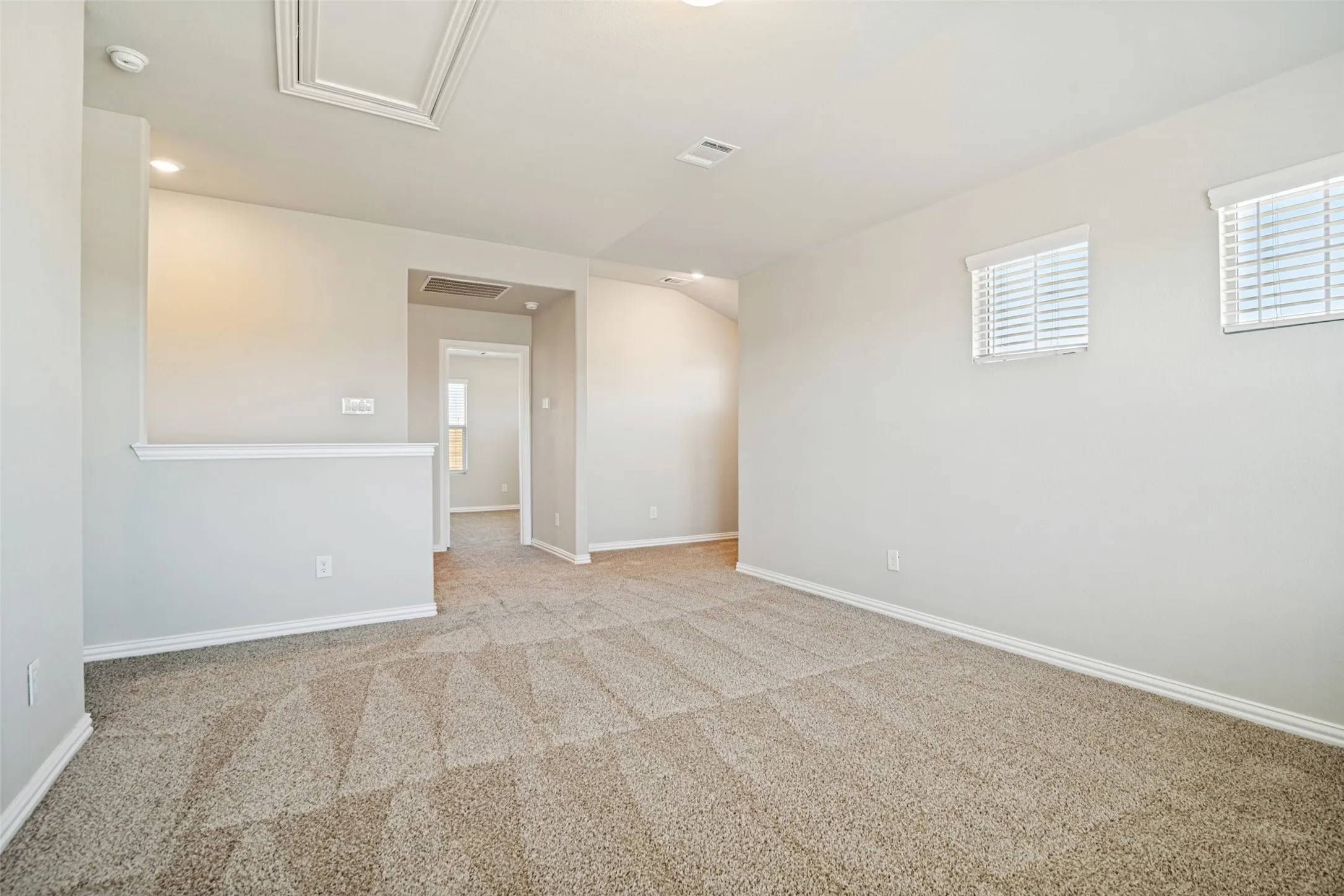 Carpeted flooring, recessed lighting, white trim, and two windows with blinds