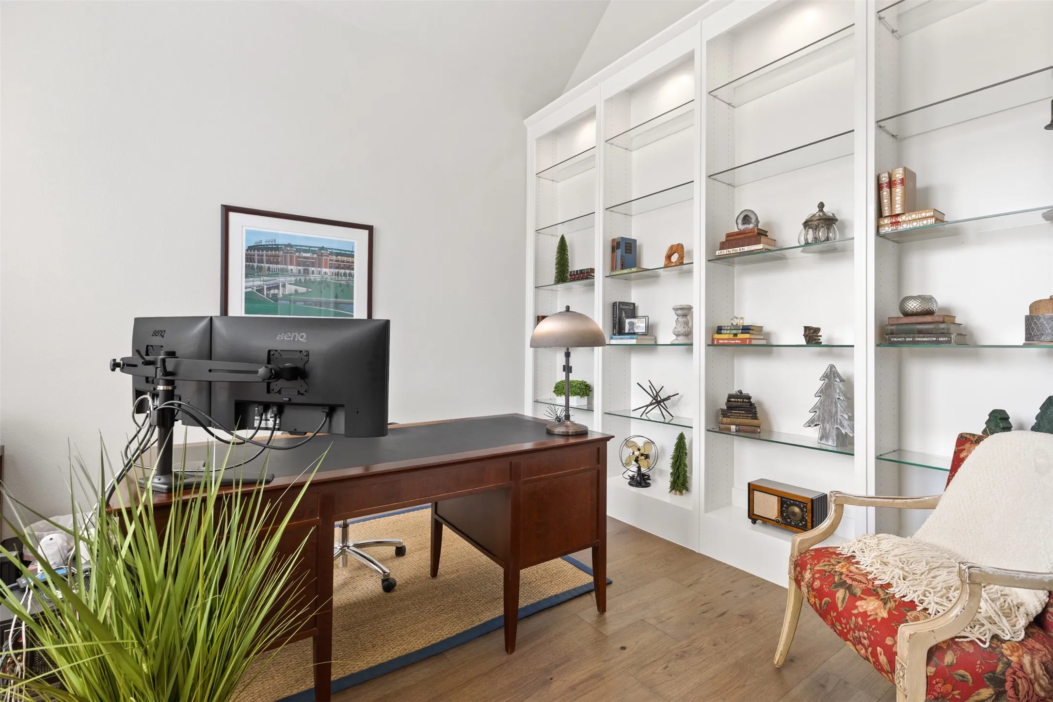 Office with Built-in shelving and ntegrated lighting, wood-finish flooring, and vaulted ceiling
